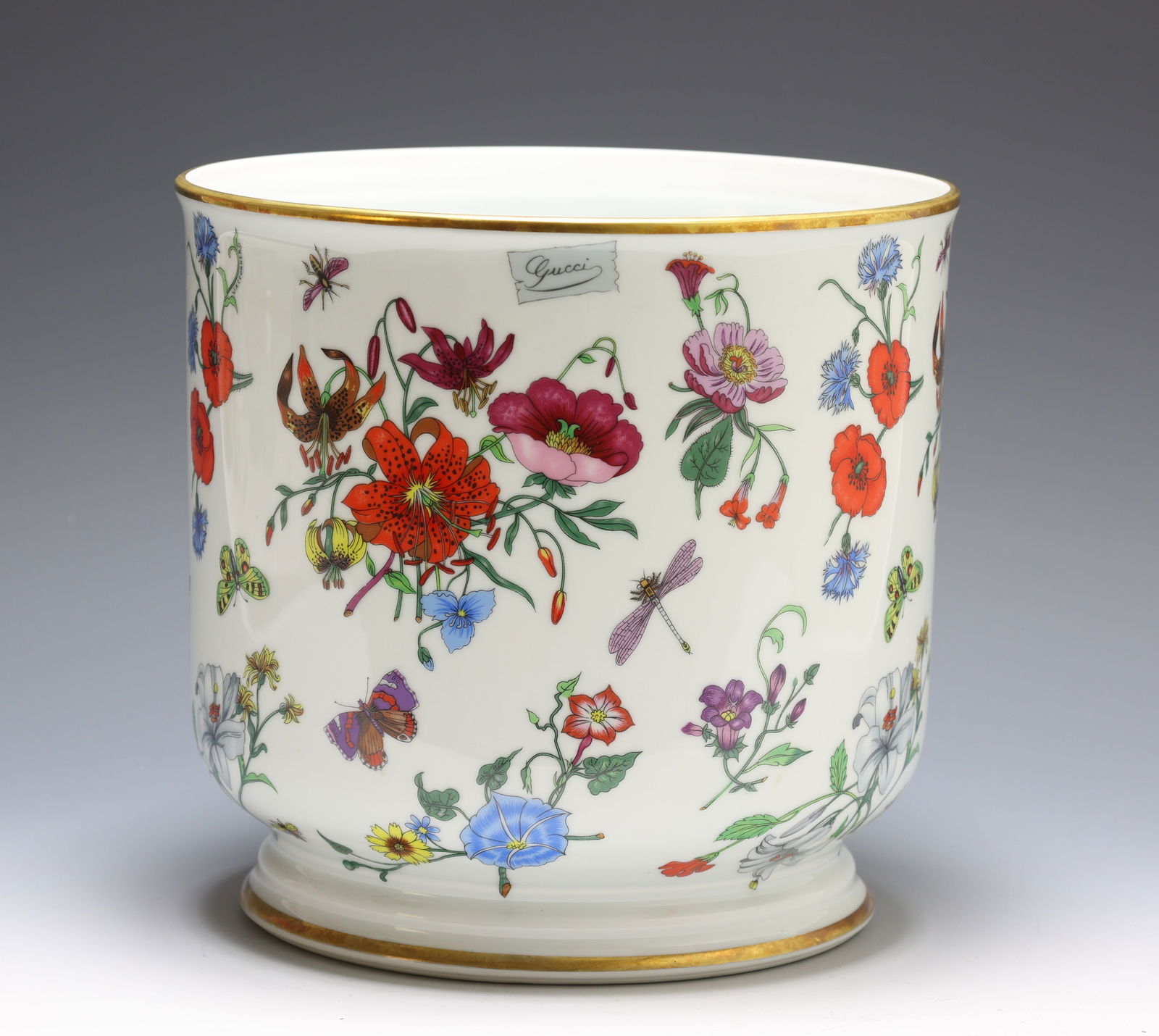 Bernardaud Limoges for Gucci Porcelain Cachepot: French porcelain footed cachepot decorated with sprigs of flowers and insects, with gilt accents. Marked for Bernardaud to the foot and Gucci to the side. Some staining to the interior. 8.5"h x 9"w