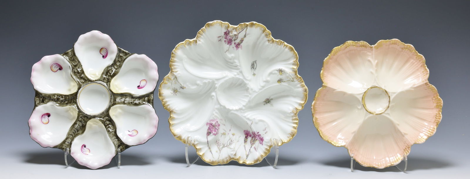 Oyster Plates: M. Redon, Limoges, porcelain 5 well oyster serving plate, pink with gilded scallop edges, marked. Tressemanes & Vogt Limoges porcelain oyster serving plate, 5 well, hand painted floral and gilt