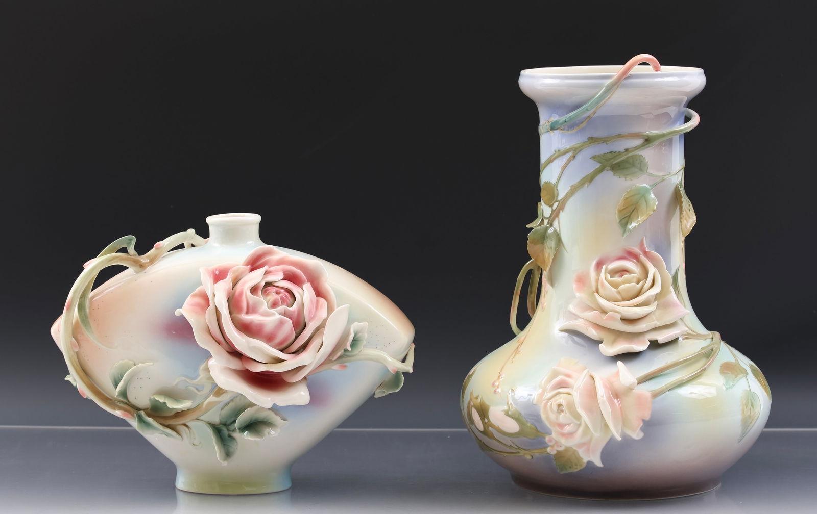 Franz Porcelain Rose Vases: Modern China pieces, including a "Rose of Peace" vase, 7.5"h x 10"w x 5.5"d, and a "Brambly Rose" vase, 12"h x 9"w, with original box. (2) vases.