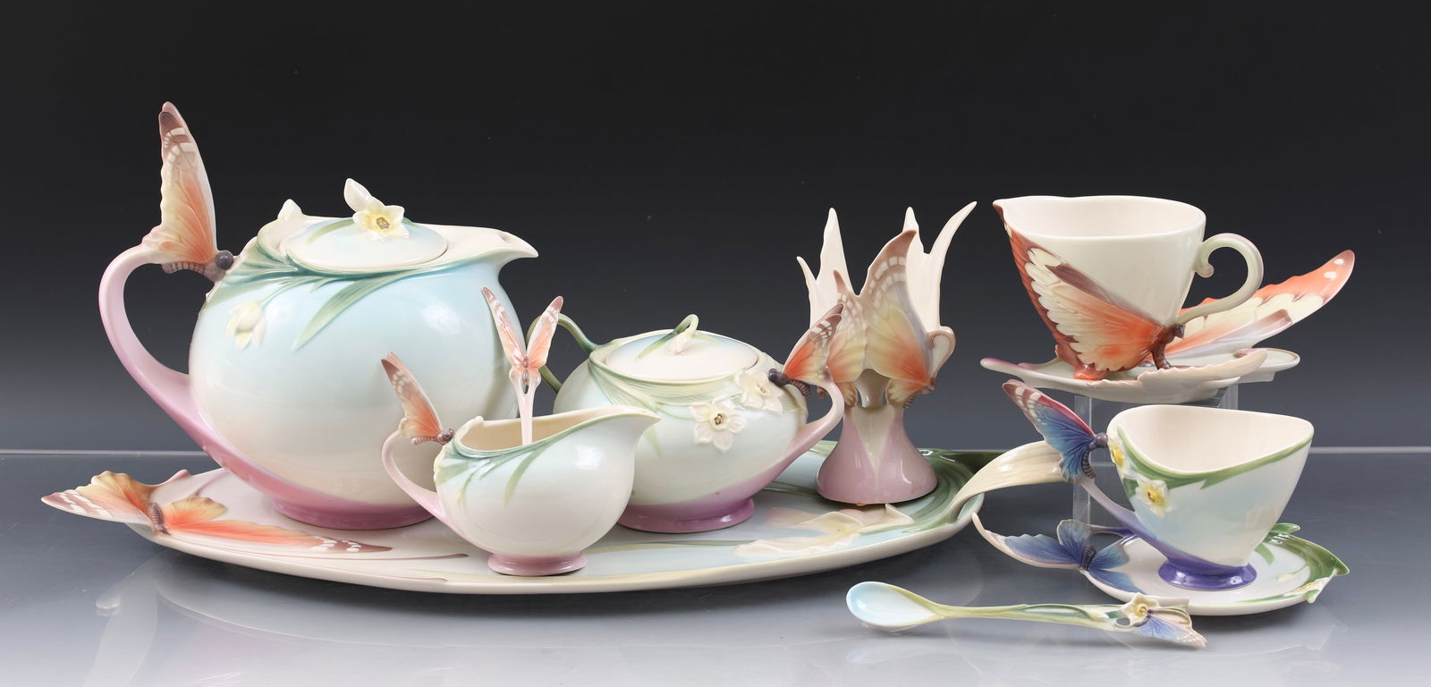 Franz "Papillon" Porcelain Teawares: Modern China wares decorated with butterflies and flowers, including a teapot (7"h x 7.5"w), a creamer (3.5"h x 4.75"w), a covered sugar bowl (3.75"h x 5.75"w), a serving tray (2.5"h x 17.5" x 9"), a