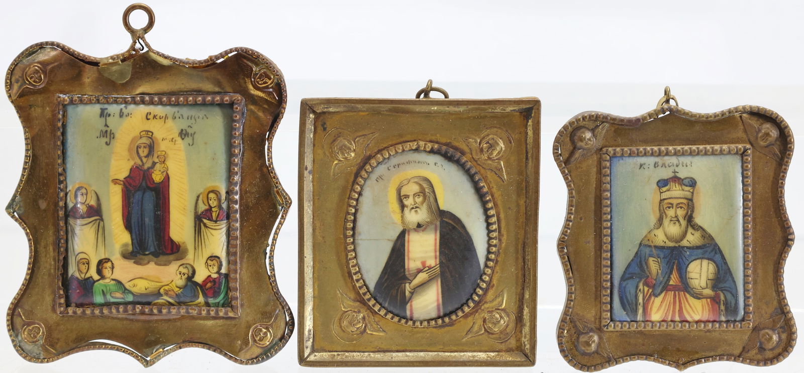 19th C. Russian Icons: 19th century Russian Orthodox painted icons, each set within brass frames, depicting the Mother of God “Quick to Hear” (Skoroposlushnitsa), Venerable Sergius of Radonezh, and Saint Basil. (3)