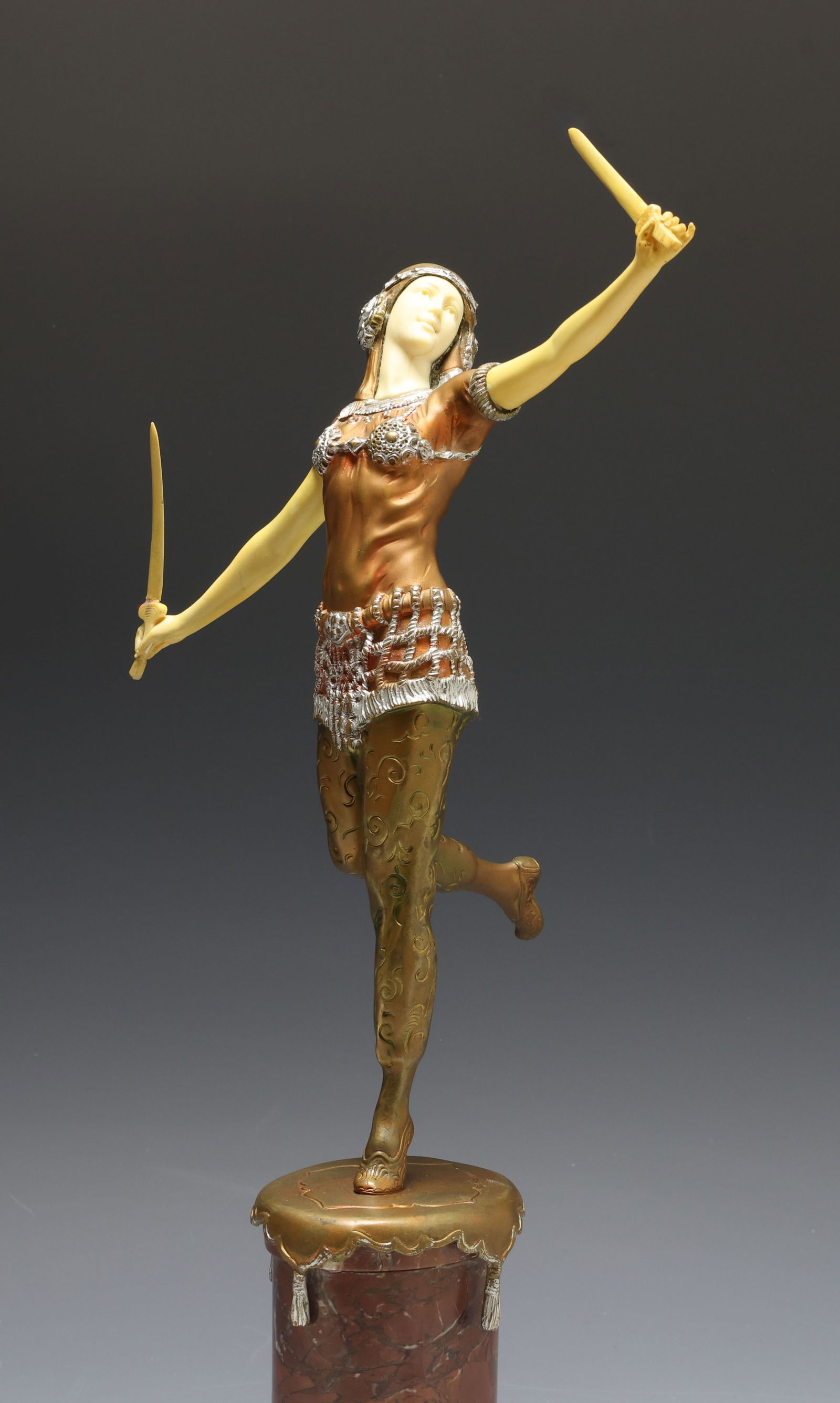 Otto Hoffmann (1885 - 1915): Art Deco figure made of bronze patinated spelter and celluloid. Standing female dancer with outstretched arms holding a sword in each hand. Raised on a marble tile pedestal. Impressed signature to