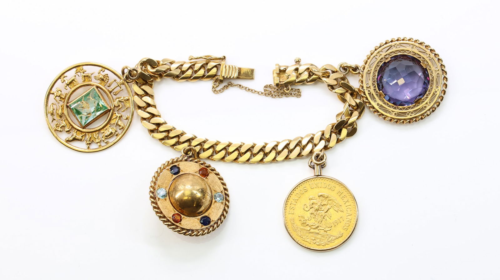 18k YG Charm Bracelet: 18k yellow gold bracelet with four principal charms: an 18k circular zodiac medallion with pierced astrological figures surrounding a square step cut topaz center of "Taurus"; an 18k domed globe
