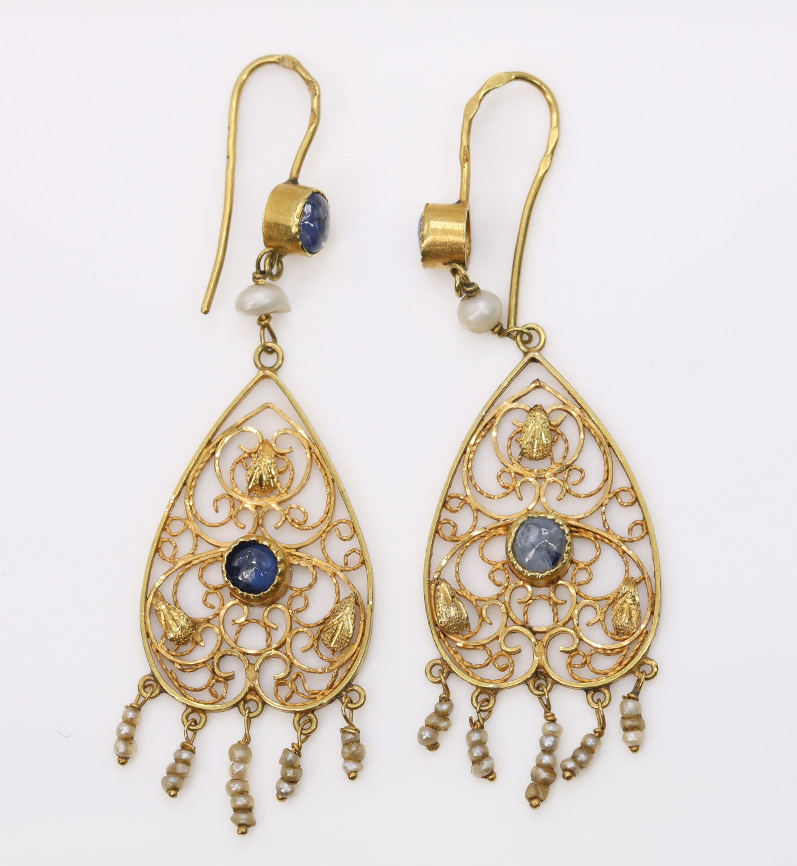 18k YG Sapphire Earrings: 18k yellow gold drop earrings set with round cut sapphires and seed pearls in openwork filigree mounts. 2.25" and 2.5dwt.