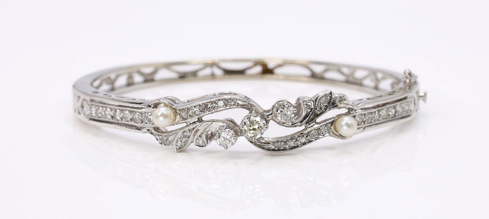 14k WG Diamond Pearl Bracelet: 14k white gold bracelet set with (35) round brilliant cut diamonds totaling approximately 1.10 carats and (2) pearls measuring approximately 3.5mm. 6.5" and 11.8dwt.