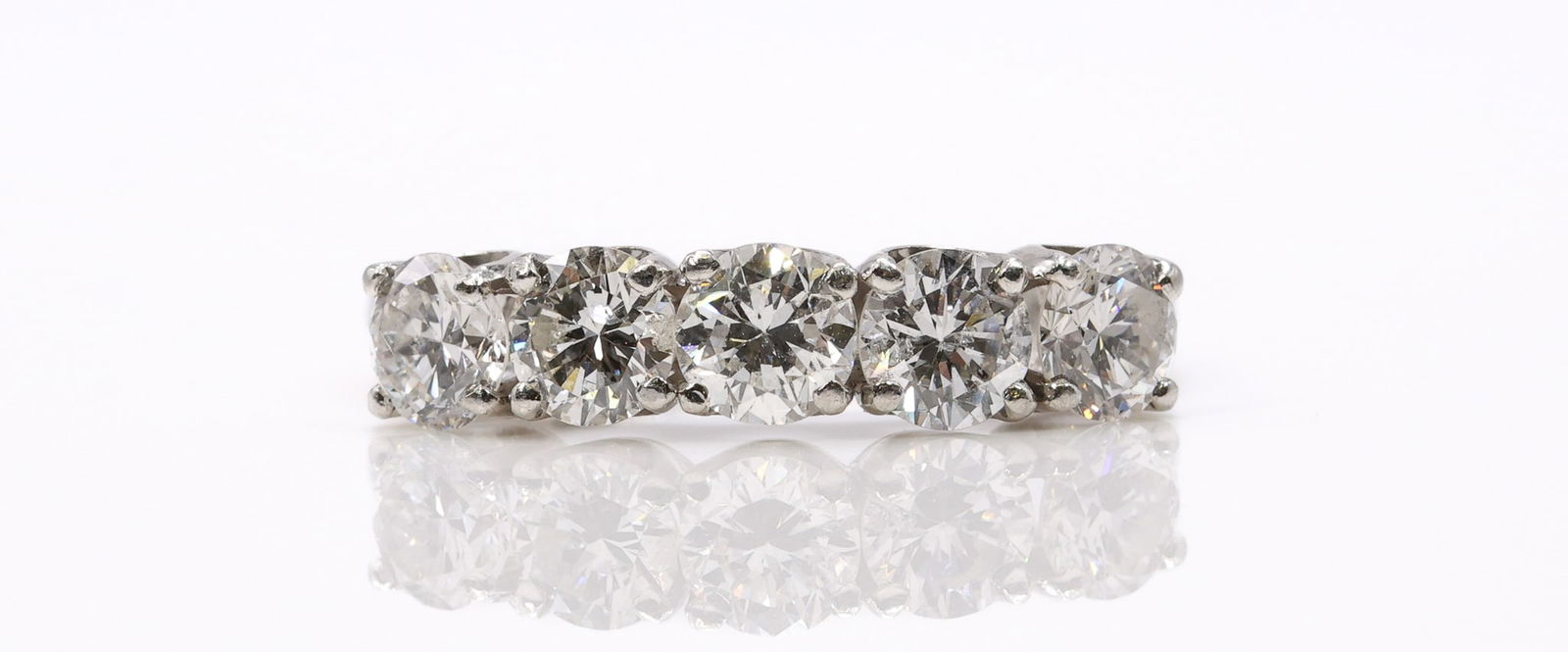 Platinum Diamond Ring: Platinum five stone diamond band set with round brilliant cut diamonds totaling approx. 1.5 carats. Size 6 and 2.9dwt.