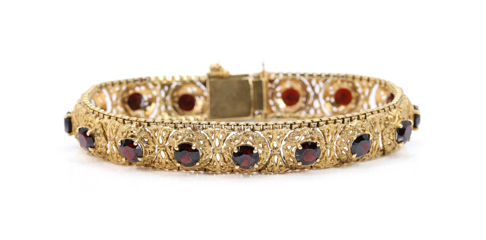 18k YG Garnet Bracelet: 18k yellow gold filigree bracelet set with approx. 16 cts of round garnets, 7.5" l., 0.5" h., 21.2 dwt.