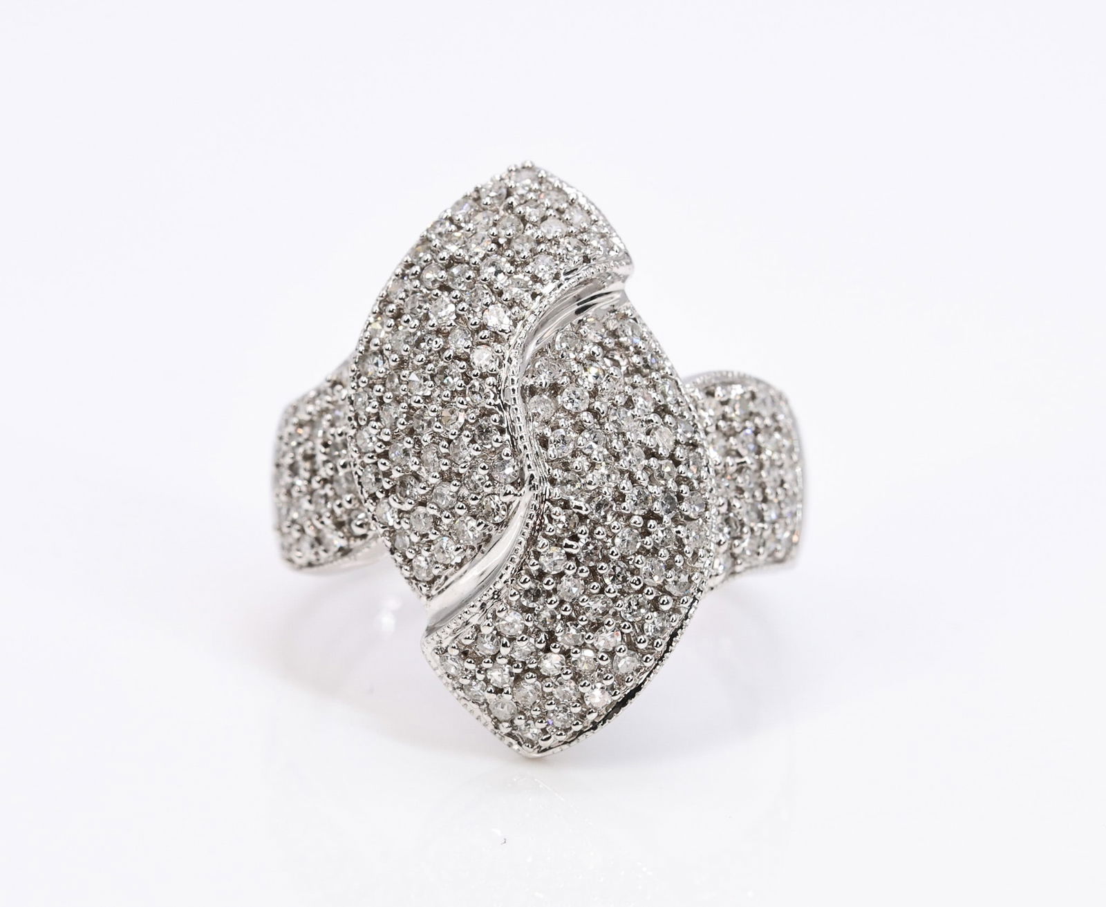 14k YG Diamond Ring: 14k white gold pavé diamond ring with a crossover design set throughout with round brilliant cut diamonds; one stone loose but present. Size 8 and 4.8 dwt.