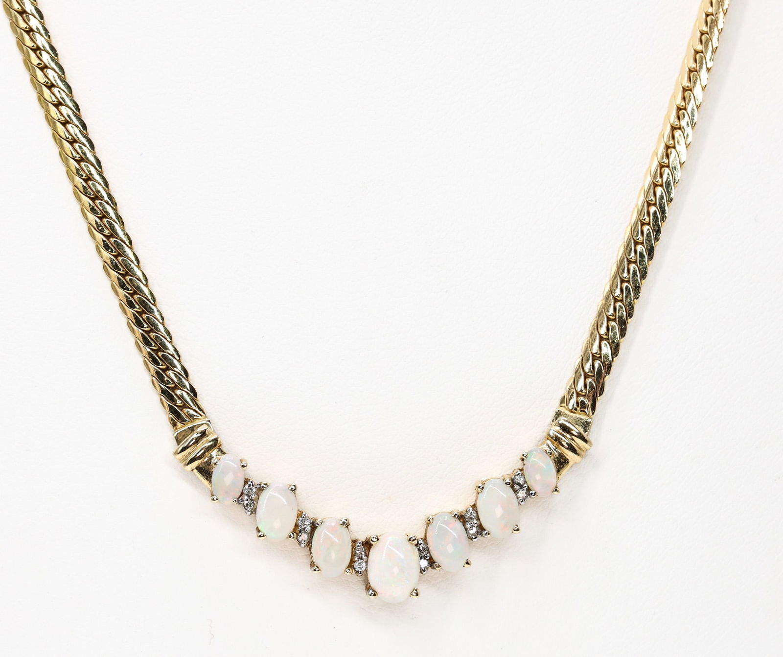 14k YG Opal Diamond Necklace: 14k yellow gold necklace set with (7) oval cabochon opals ranging from 5.2mm to 7.3mm, accented by round cut diamonds along a "V" link chain. 17" and 6.9dwt.