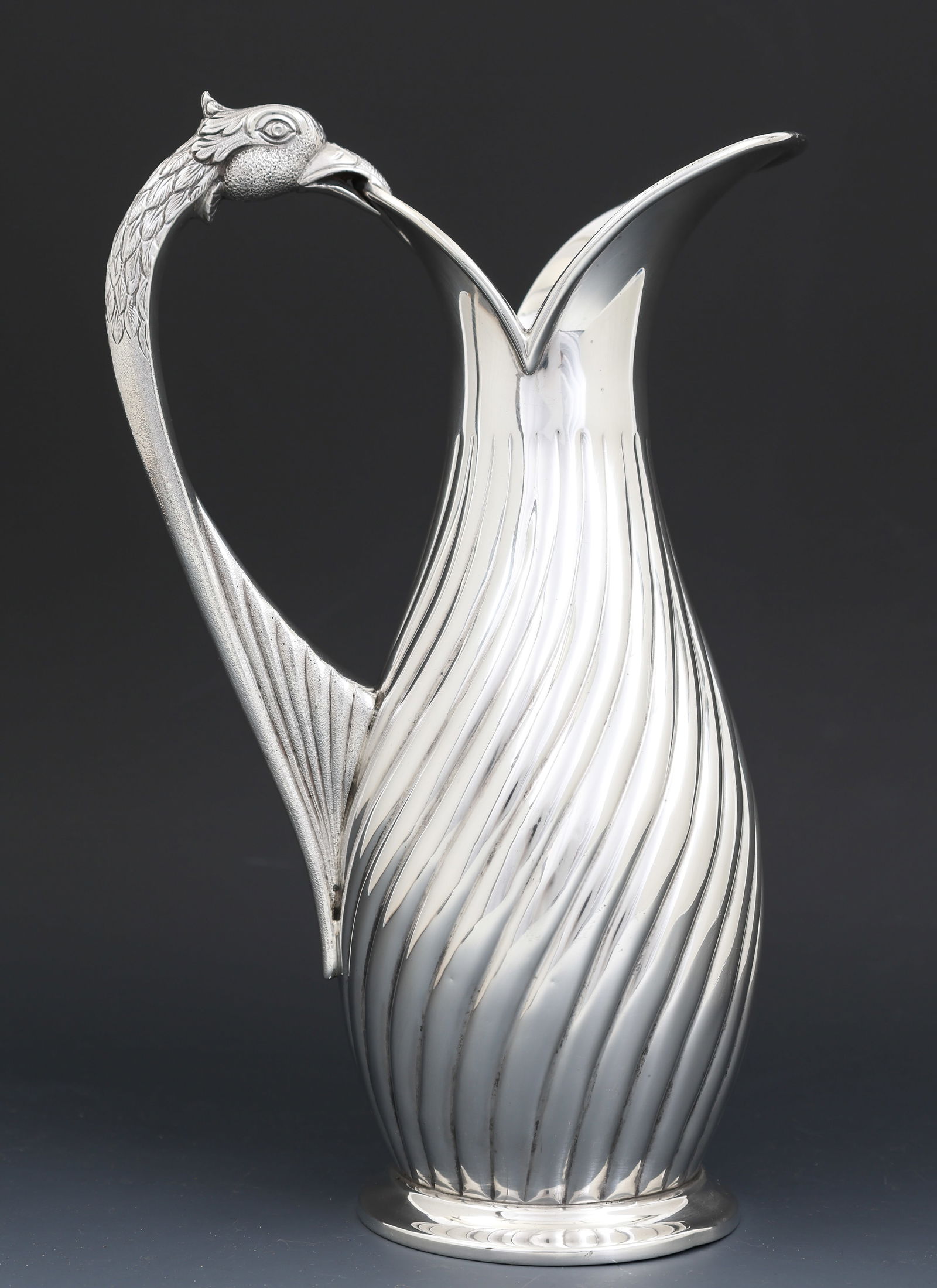 Sterling Silver Figural Ewer: Figural ewer with reeded swirl decoration and a handle in the form of a bird's head. Unidentified makers mark, possibly from Argentina. There are two small dents to the foot rim. 10.25"h x 6.5"w.