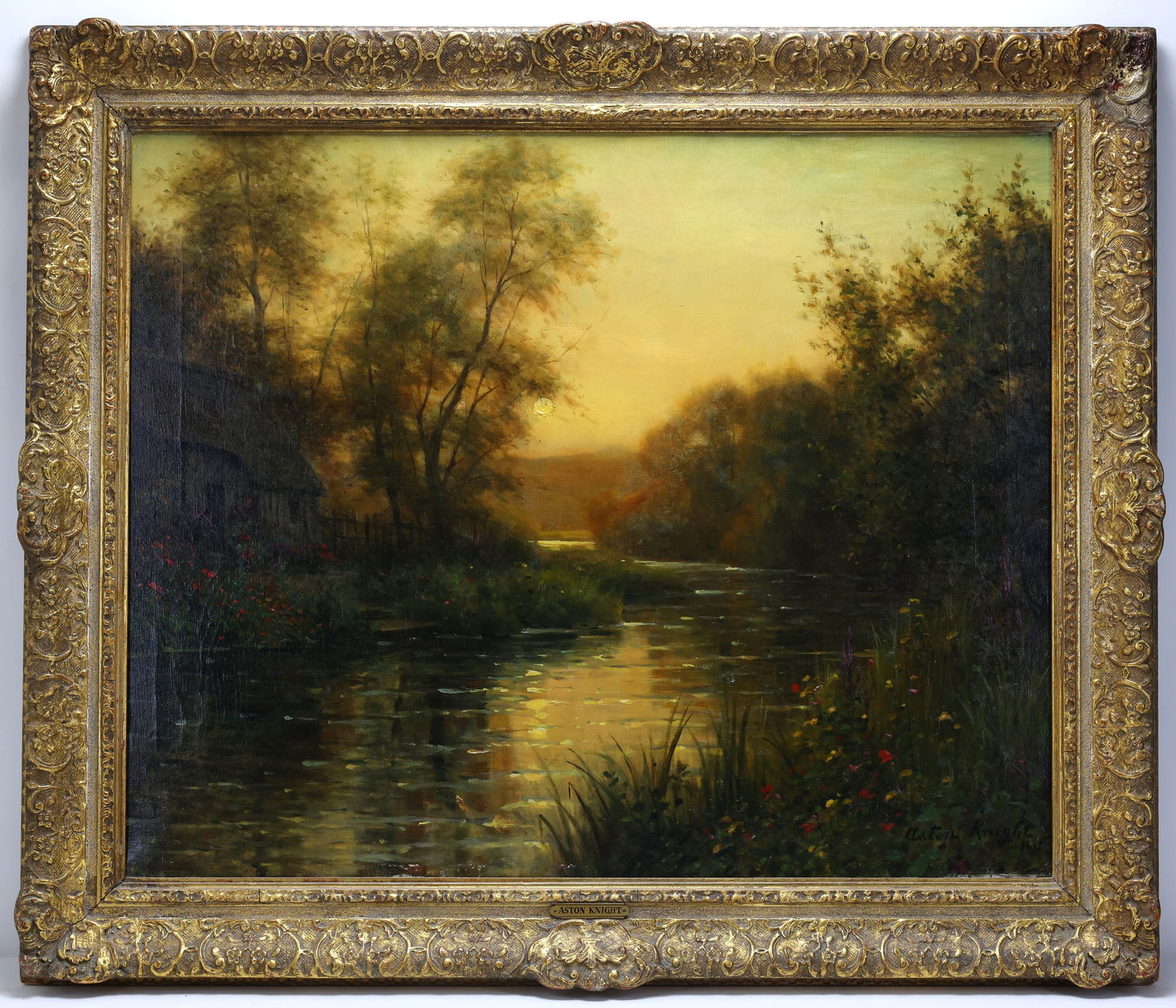 Louis Aston Knight (1873 - 1948): Oil on canvas, SLR. Tonalist landscape with glowing sunset over a reflective river flanked by trees and a cottage. 26"h x 32.5"w and 32.5"h x 38.5"w framed