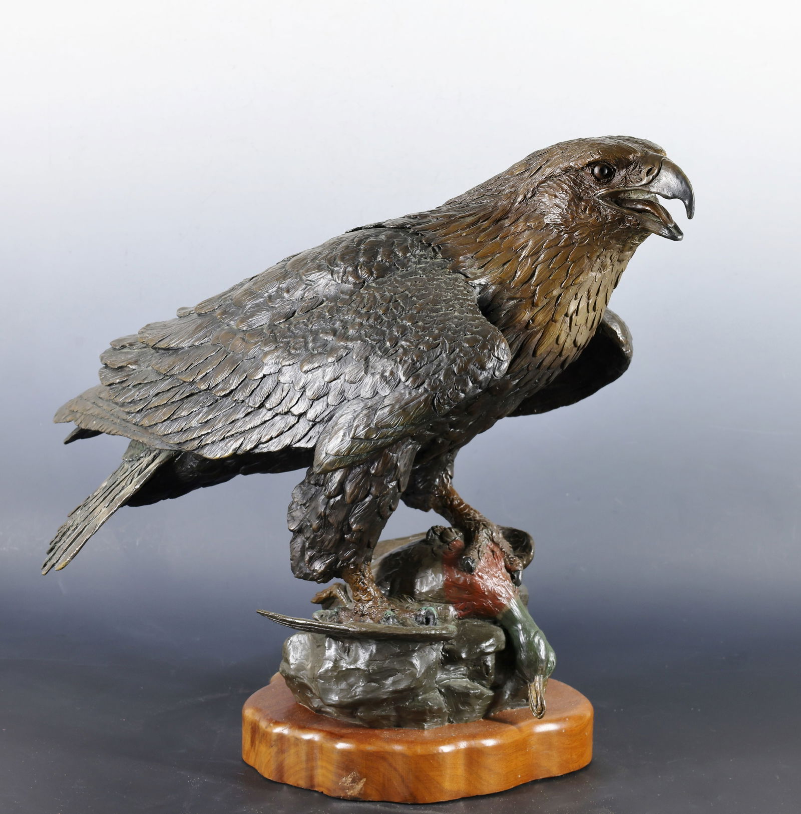 William H. Turner (B. 1943): Bronze sculpture, depicting a bald eagle and mallard, impressed signature to the base, dated 1994, and numbered 37/50. Mounted to a wood stand. The stand shows a scuff. 18"h x 19"w x 9.5"d