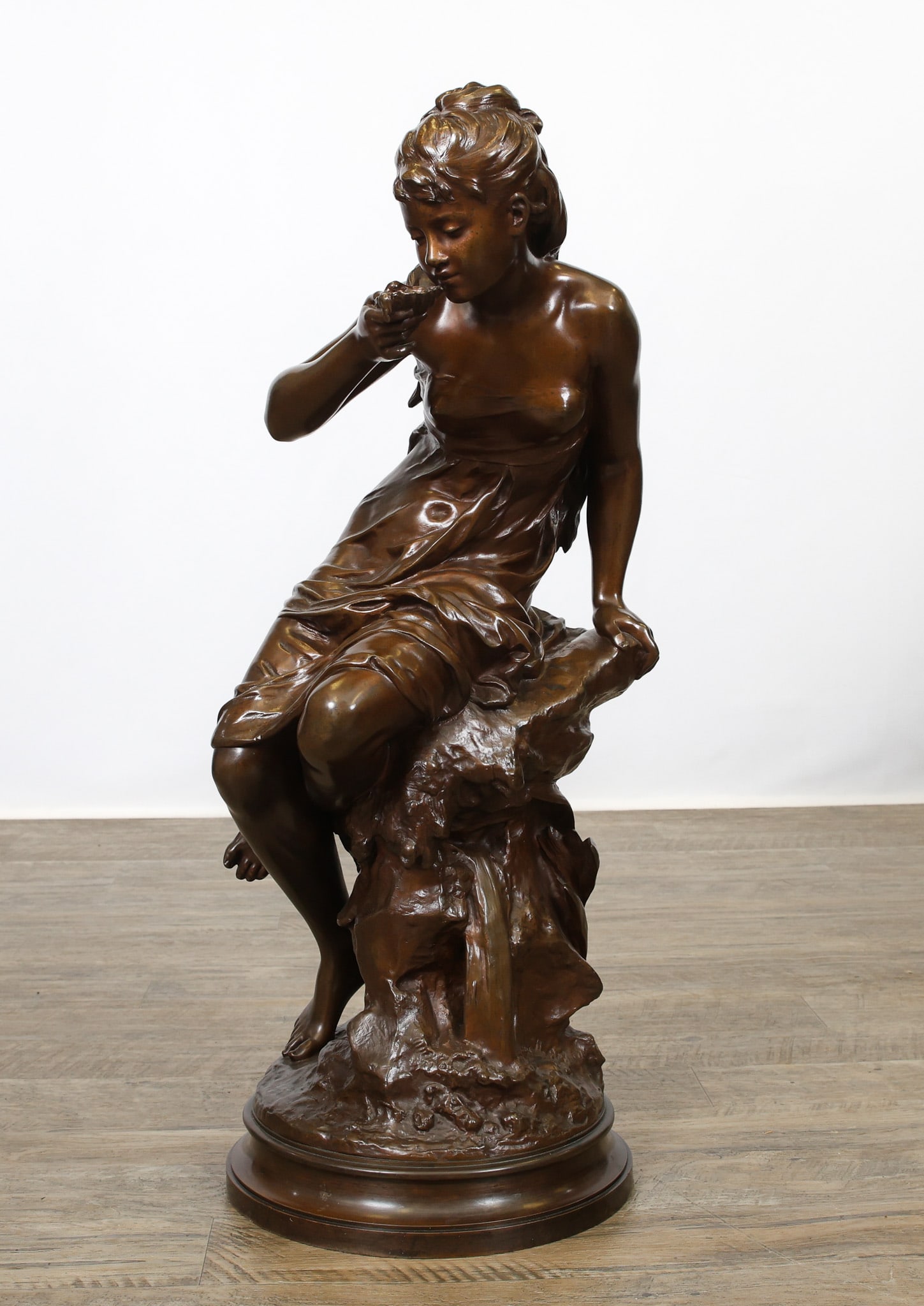 Mathurin Moreau (1822 - 1912): French bronze sculpture, "La Source (The Spring)", depicting a semi-nude young woman taking a drink by a spring. Impressed signature and foundry mark for E. Colin & Cie, Paris near the base. The base