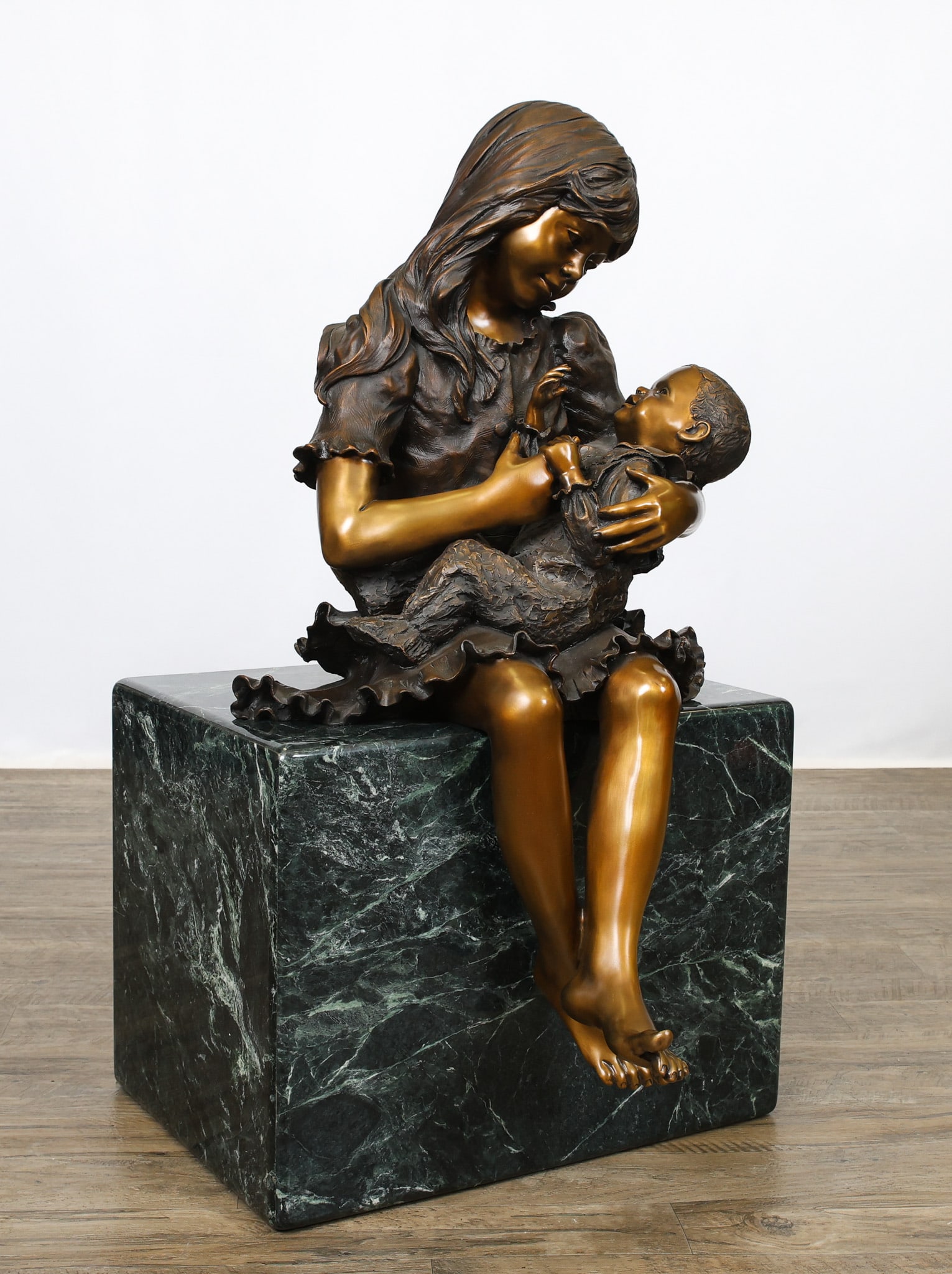H. Blair Muhlestein (1936 - 2012): Bronze sculpture, "Little Mother", depicting a girl holding a baby, impressed signature to the girl's skirt and numbered 18/21, sitting on a marble plinth (the bolts are not attached). 37.5"h x 21"w