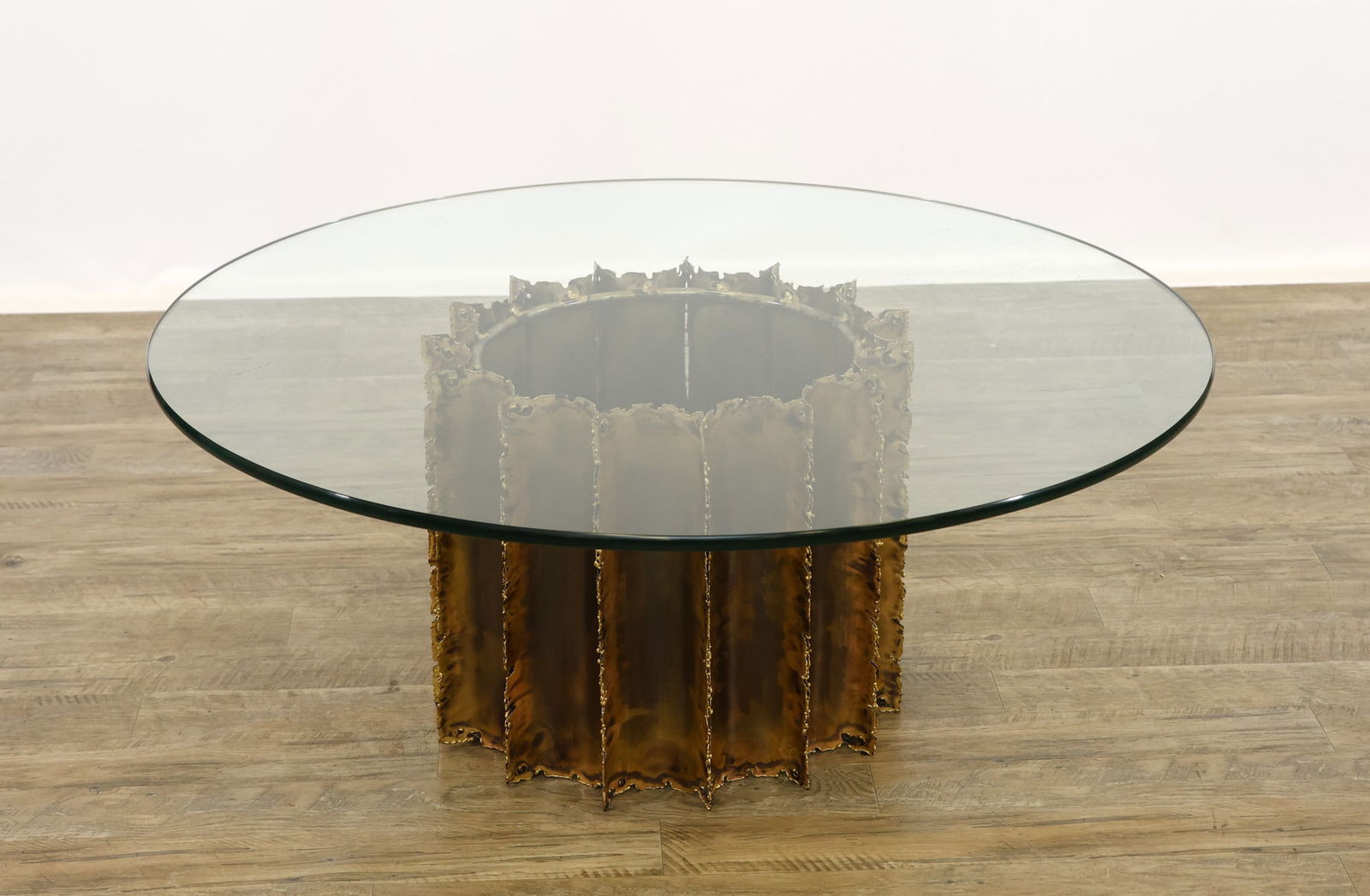 Attr. Tom Greene Brutalist Coffee Table: Brutalist coffee table with a torch cut brass drum base and a round glass top. 17"h x 42"w