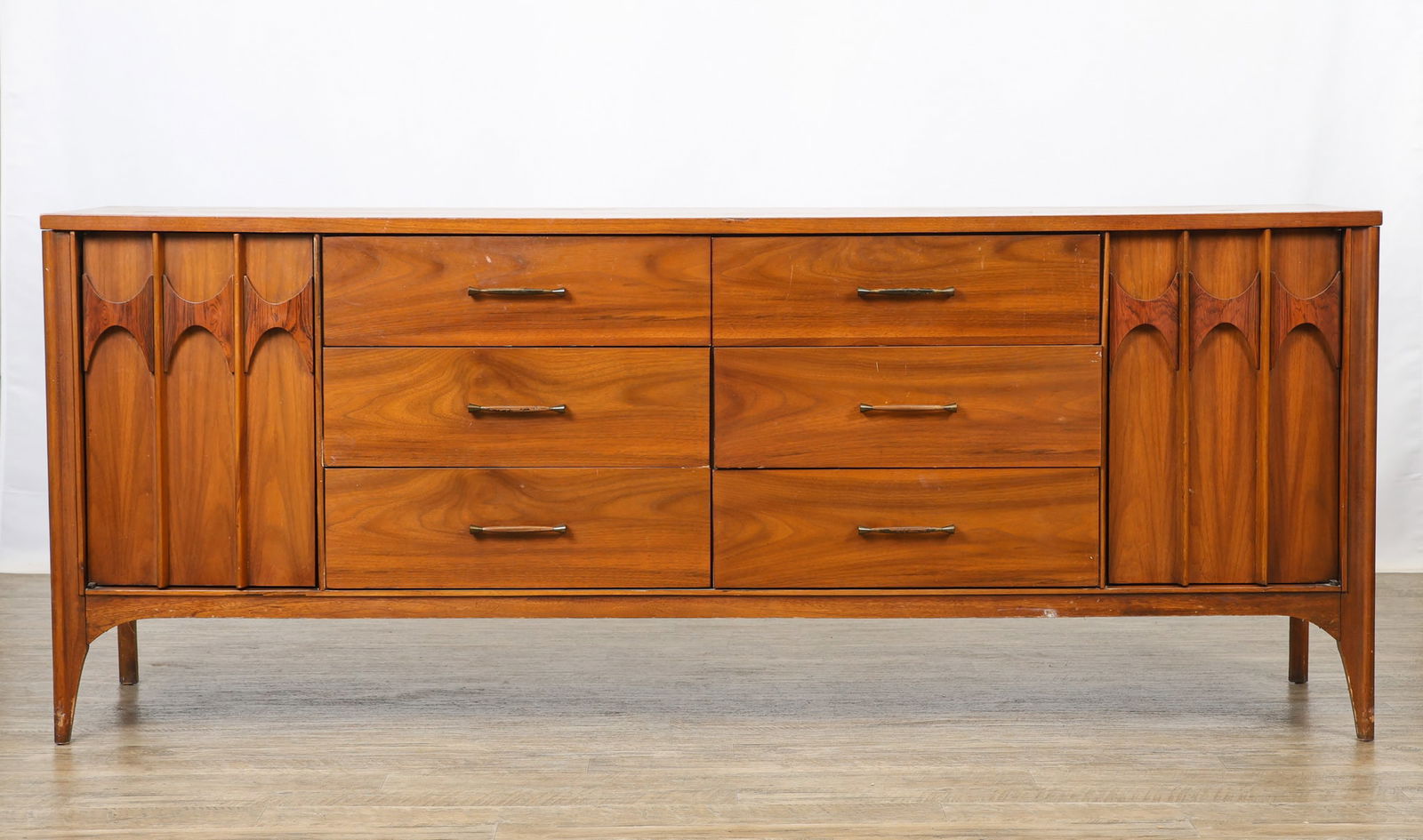Kent Coffey "Perspecta" Dresser: Walnut dresser with figured rosewood panels, featuring six drawers flanked by doors which each open to three pull-outs, with figured molding and legs. Marked to the interior of a drawer and en verso.