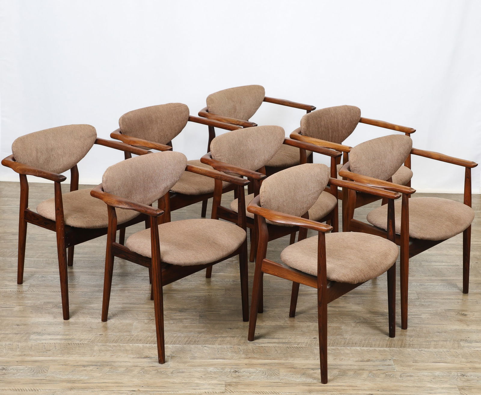 Finn Juhl for Niels Vodder Model 109 Chairs: Danish Modern rosewood armchairs featuring bent cigar stiles, cigar front legs, offset shaped stretchers, curved backs which extend to sculptured arms with a hollow at the tip, upholstered floating