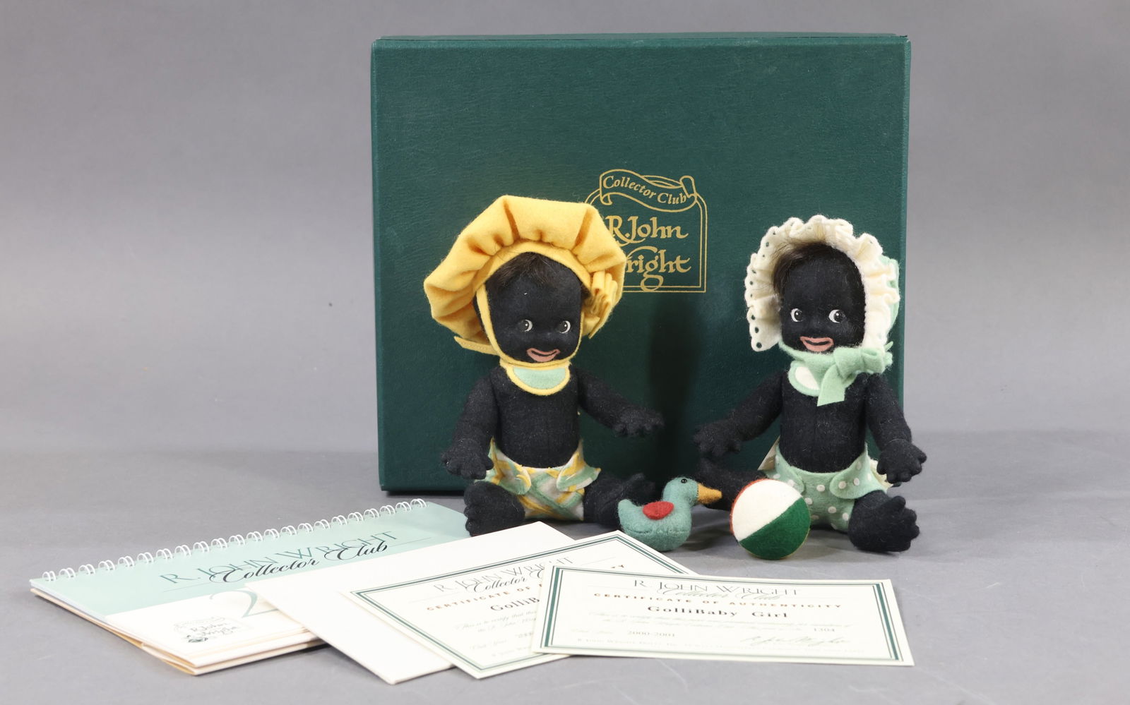 R. JOHN WRIGHT.: Pair of MIB 2000-2001 Collector's Club Dolls - 6" "Gollibaby Girl" and "Gollibaby Boy" dolls. Both have their COA and are numbered 1304/. Each one has a felt toy. Condition: minor age discoloration