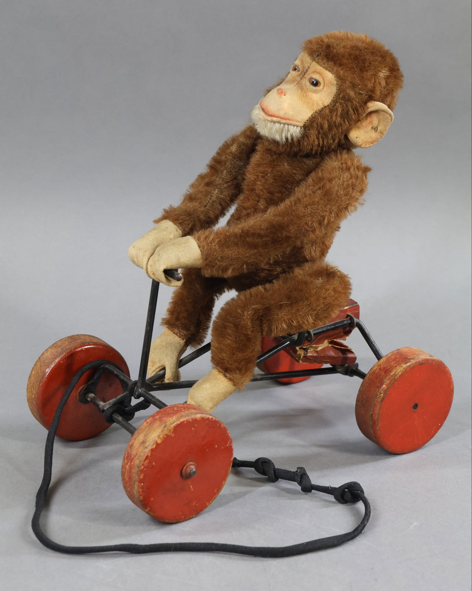 VINTAGE STEIFF.: 10" T x 9" L x 5 1/2" W 1912-1925 "Record Peter" Monkey. Brown mohair plush substitute with camel felt face, ears, hands, feet. White mohair chin. Amber glass eyes. Jointed Monkey sitting on metal car