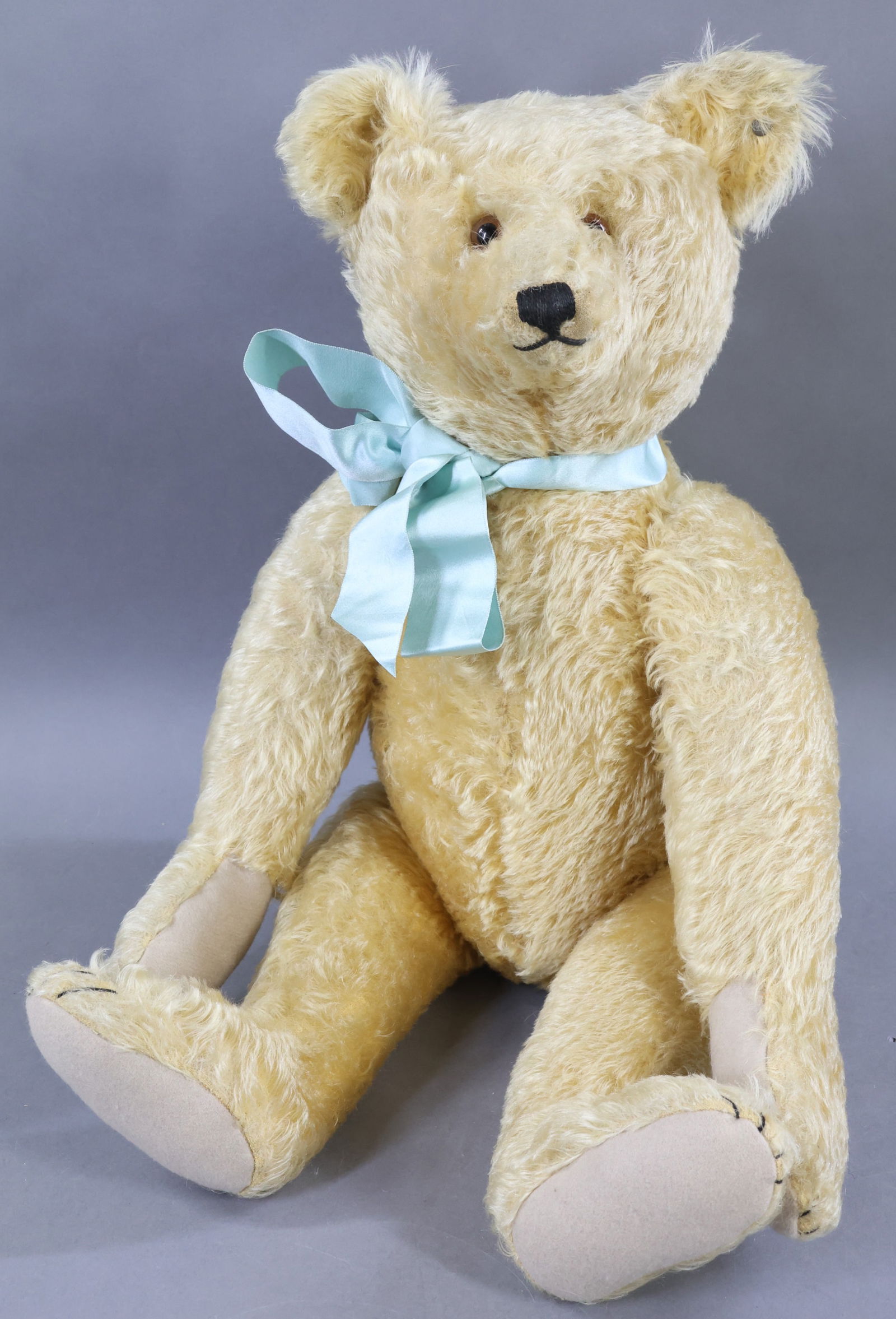 VINTAGE STEIFF.: 25" 1926-1927 "Teddy Bear". (5343,1 K) Blonde curly mohair with brown glass eyes. Fully jointed with swivel neck, elongated snout and arms. Growler. Bear is filled with Kapok which was only used in pr