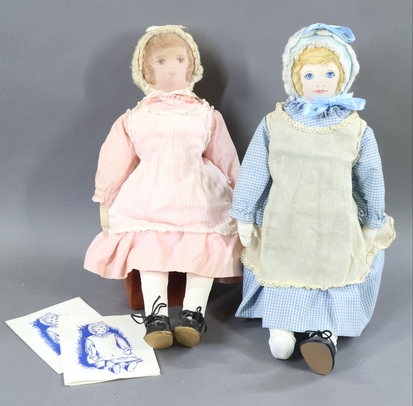 AMERICAN CLOTH DOLLS.: Pair of all original 18" "Polly Heckewelder" dolls made by the Moravian Church Ladies Sewing Society in Bethlehem, PA. The brunette doll in pink appears to be from the late 1950's to the early 1960's