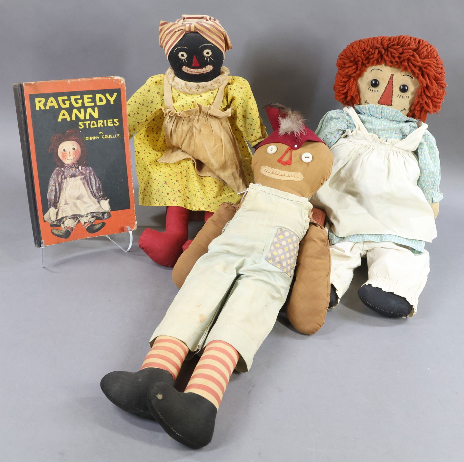 AMERICAN CLOTH DOLLS.: LOT of (3) handmade dolls, book. 20" "Raggedy Ann" (1930's-40's). 20" Gruelle "Cookie Man" (1930's). 18" "Beloved Belindy". Book - "Raggedy Ann Stories", Gruelle, 1938. Condition: age discoloration,
