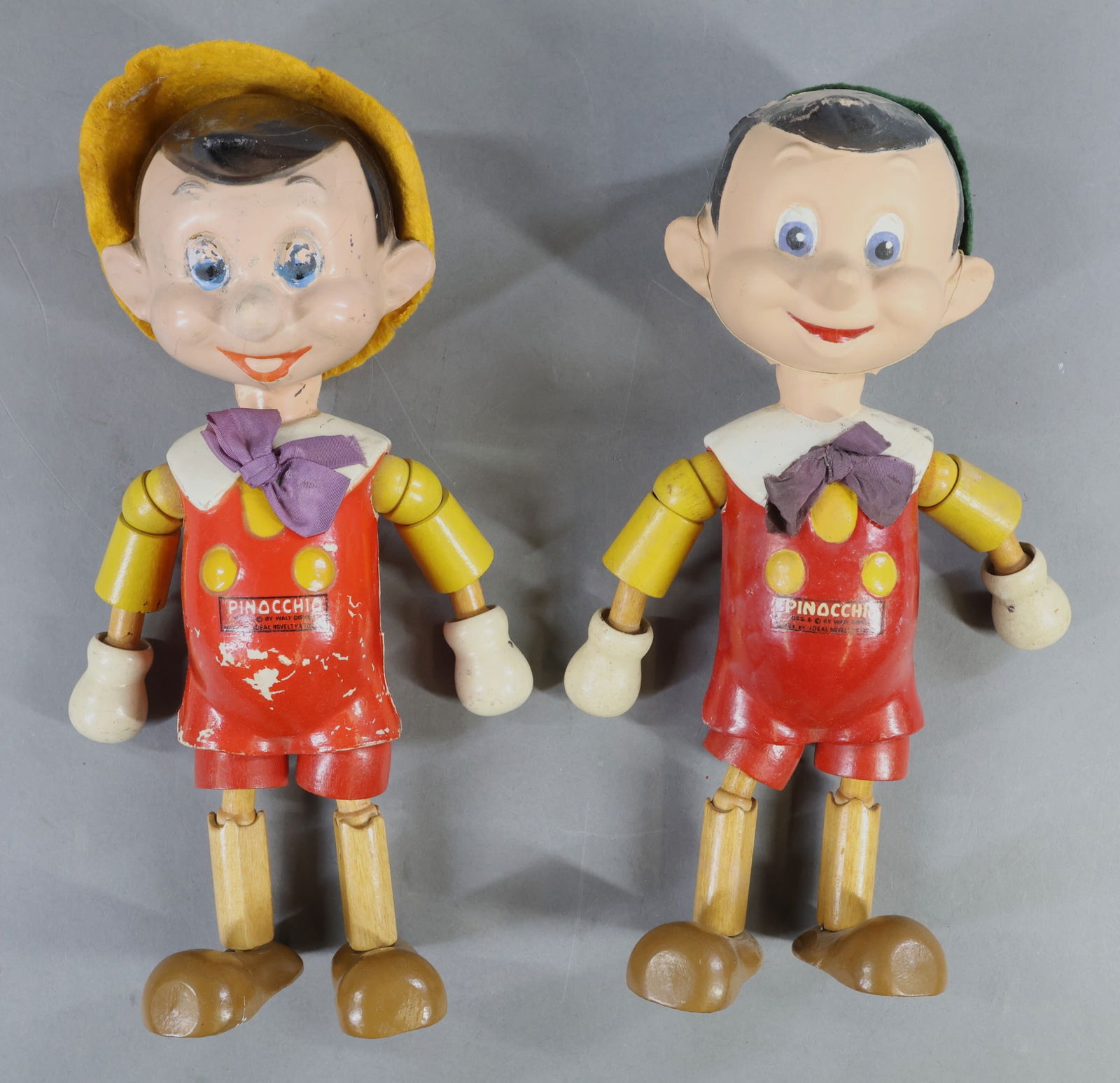 COMPOSITION DOLLS.: Pair of 1940 10 1/2" "Pinocchio" dolls. Label reads: Des. & (c) by Walt Disney, Made by IDEAL Novelty & Toy Co. These are composition and wood segmented character dolls. They are identical in