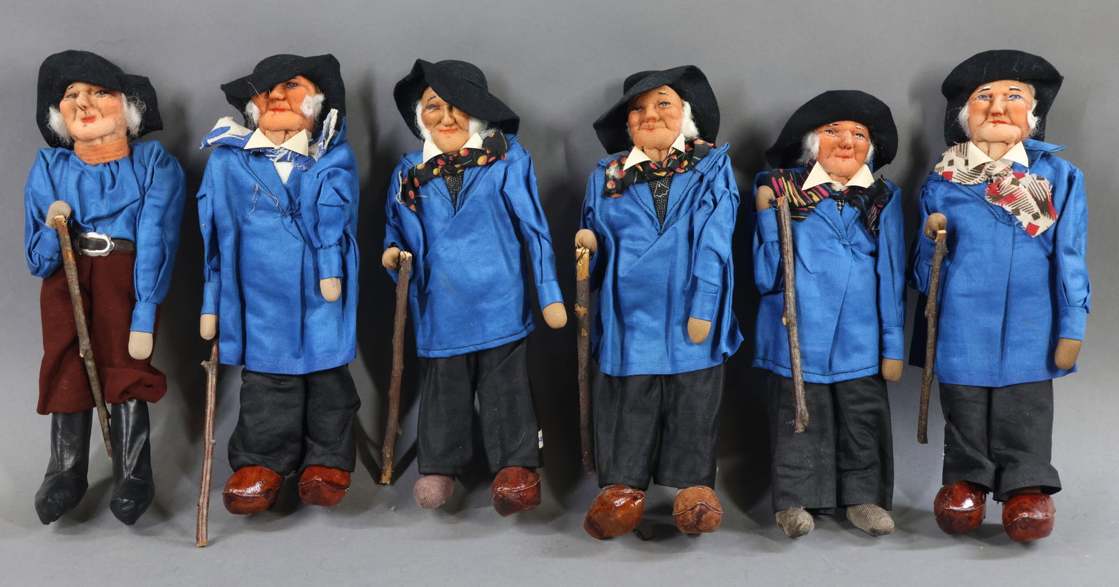 RAVCA.: LOT of (6) 10" Elderly Male Bernard Ravca dolls. All are marked Made in France. (5) Are dressed in identical outfits. (3) Clogs are missing. The last doll is dressed differently and is wearing knee