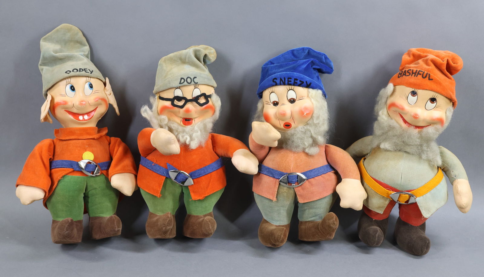 AMERICAN CLOTH DOLLS.: LOT of (4) 11" unmarked "Dwarfs" from "Snow White". They all have painted mask faces, cloth hands, velveteen clothing. Each of them are named on hats. "Doc", "Dopey", "Bashful" and "Sneezy".