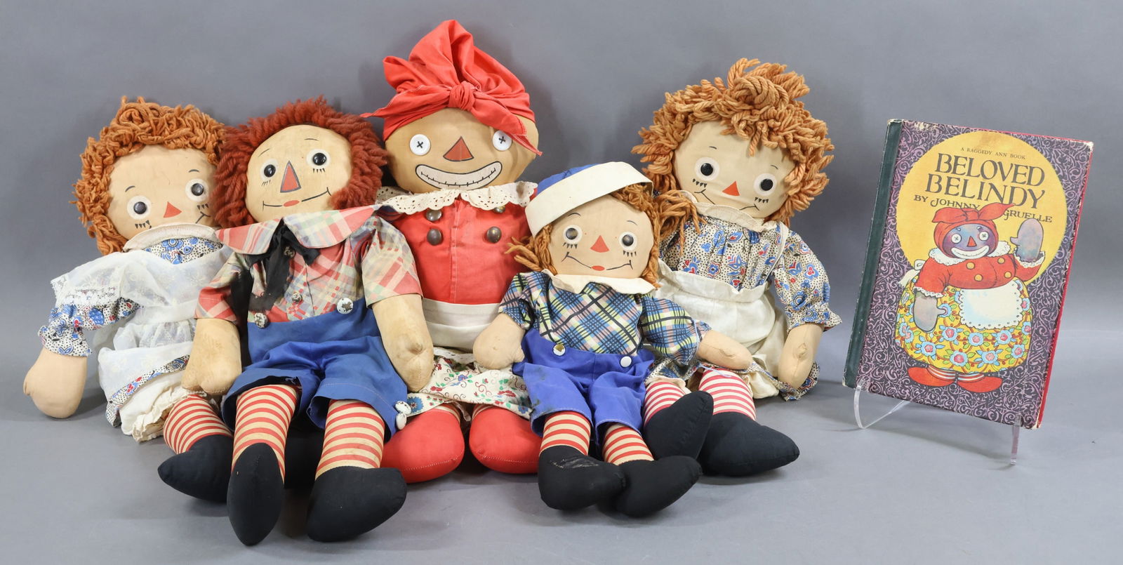 AMERICAN CLOTH DOLLS.: LOT of Raggedy Ann and Andy and Beloved Belindy Dolls. Pair of 19" tagged GEORGENE Raggedy Ann dolls wearing the same print dress. (1) Apron has been replaced. 15" Tagged GEORGENE Raggedy Andy doll