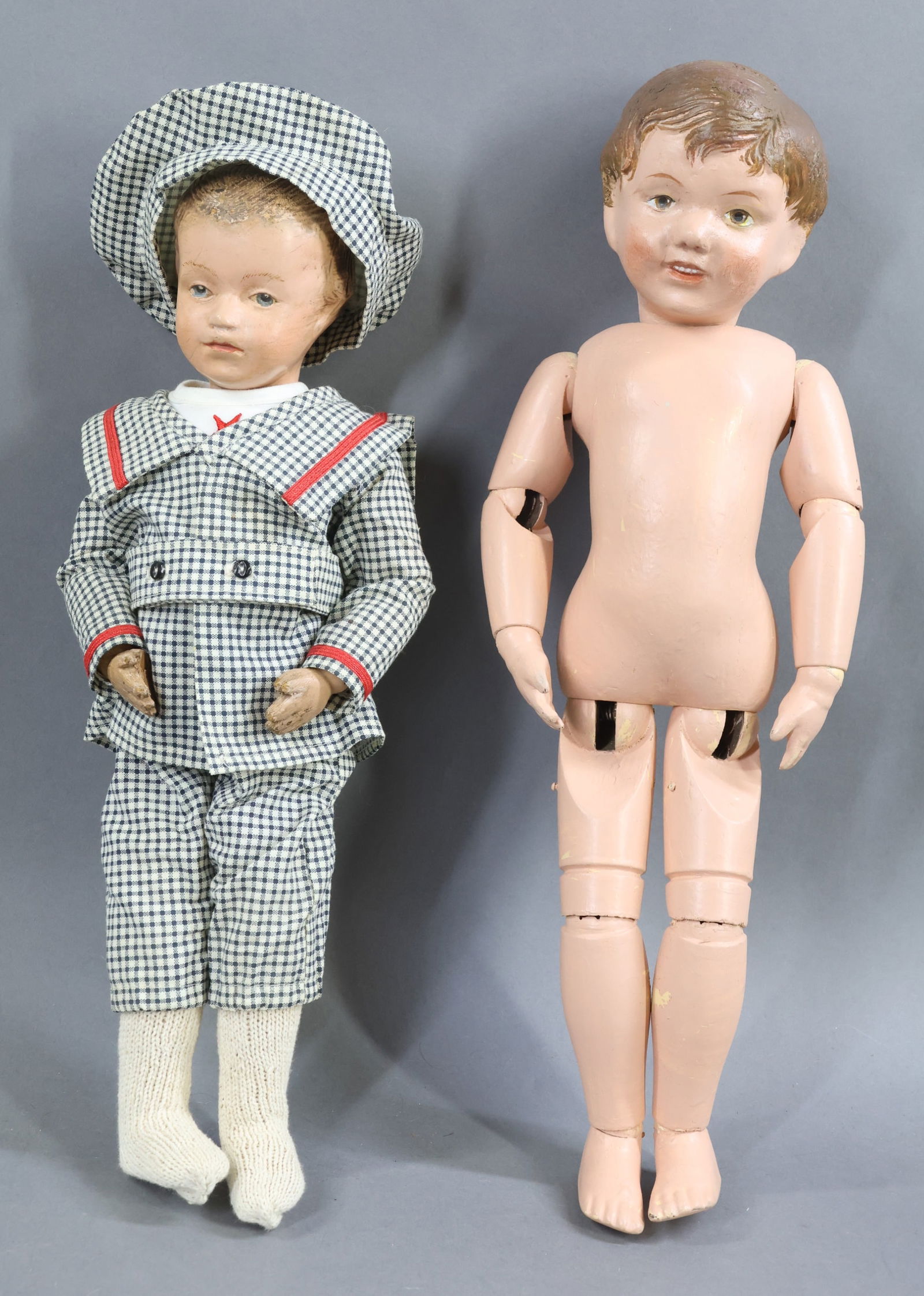 SCHOENHUT.: Pair of carved head male dolls. Doll 1) 16" Model No. 203 with brown intaglio eyes. Incised mark on back of torso. No clothing. Condition: doll has been completely repainted. Doll 2) 14" Model No.
