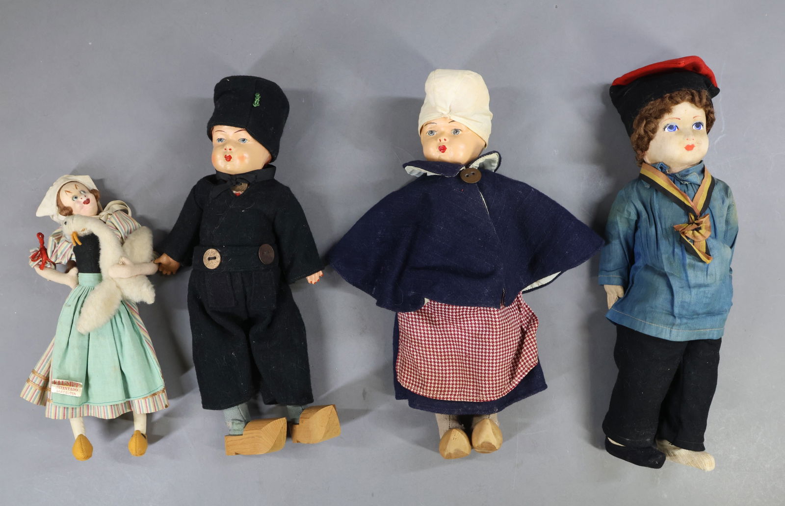 DOLLS REPRESENTING FOREIGN COUNTRIES.: LOT. 11" Tagged cloth KLUMPE Lady doll holding a goose. All original, she is tagged on back and front. Made in Spain, Patentado Barcelona. 15" Cloth mask face French boy doll. Curly brown mohair wig.