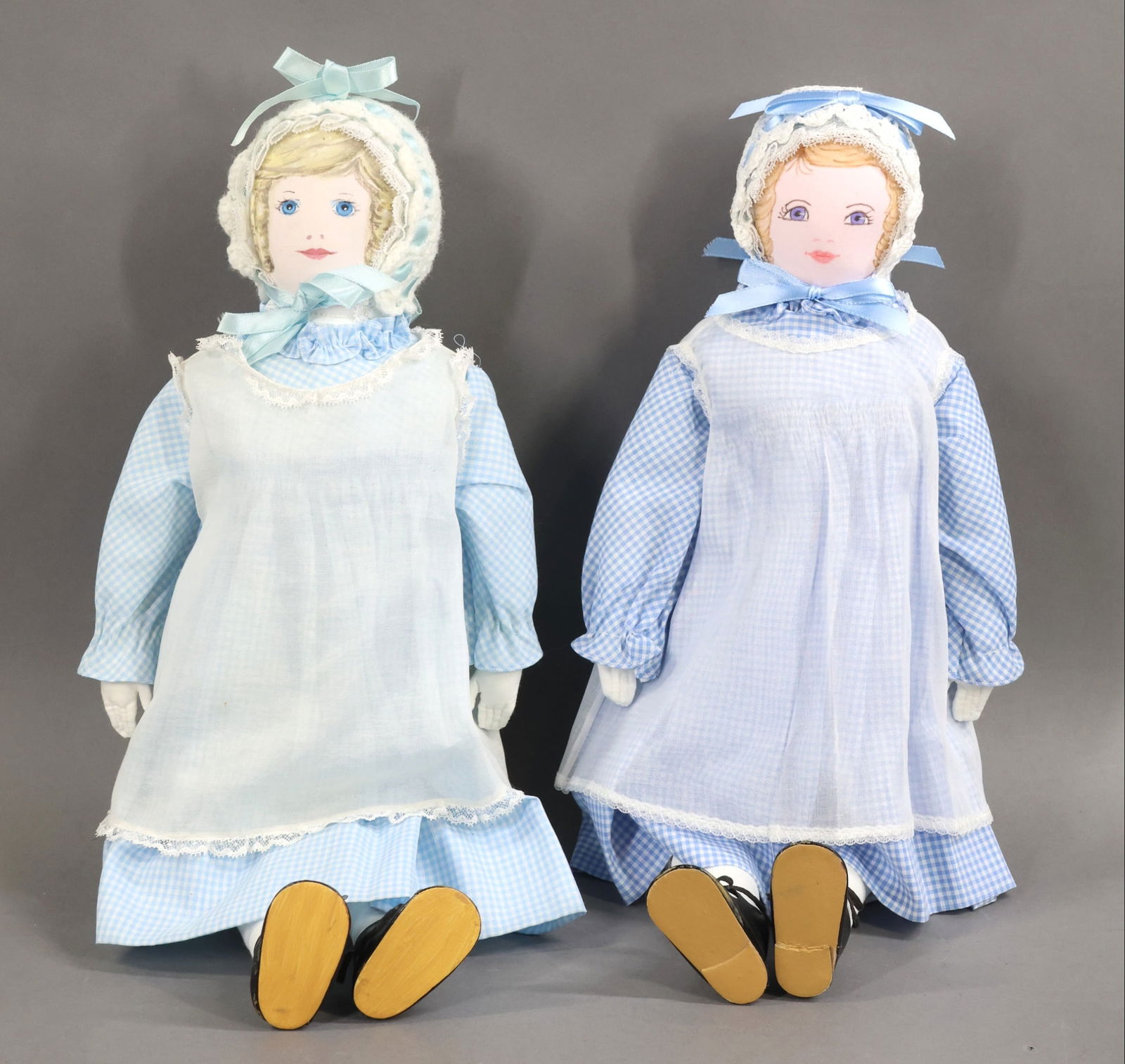 AMERICAN CLOTH DOLLS.: Pair of all original 18" "Polly Heckewelder" dolls made by the Moravian Church Ladies Sewing Society in Bethlehem, PA. Both dressed in blue/white gingham and having blonde hair, they appear to be from