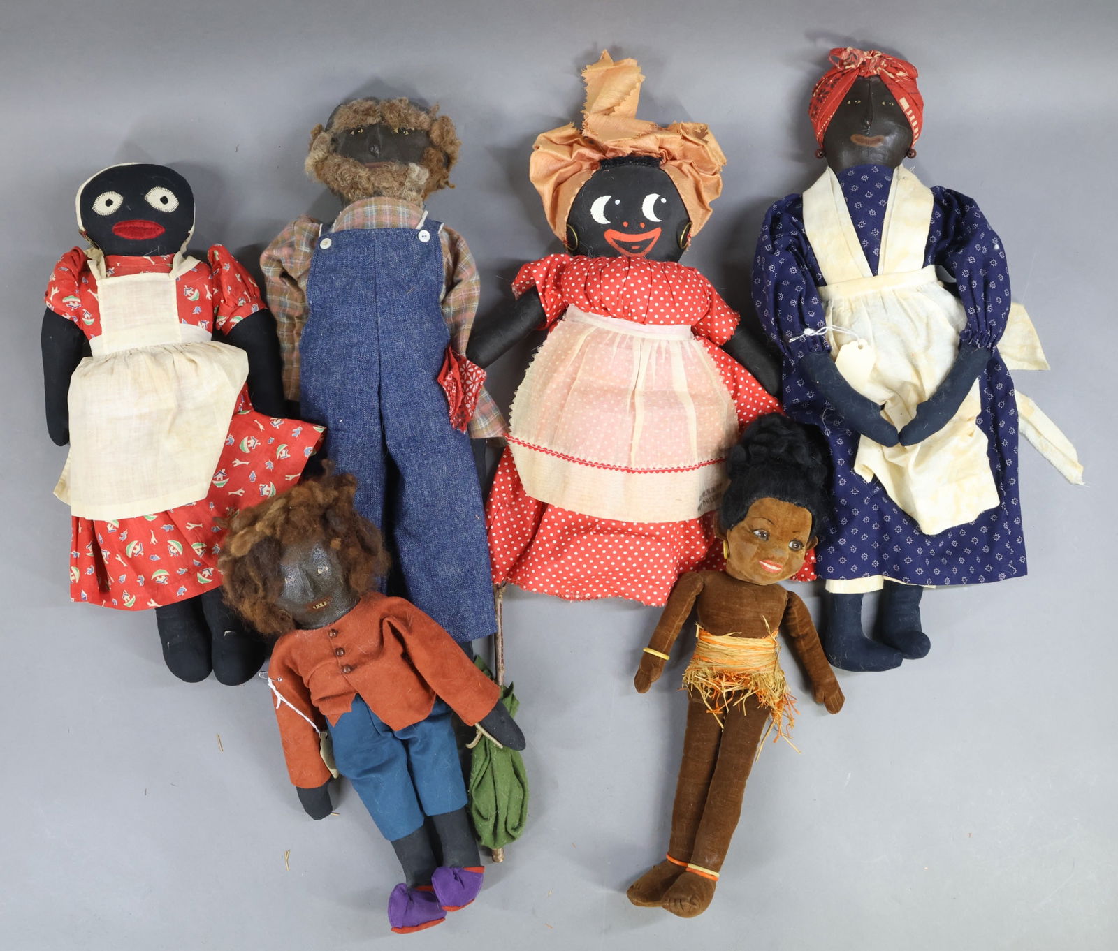BLACK DOLLS.: LOT of (6) cloth dolls. 14" Tagged NORAH WELLINGS "Island Girl" with glass eyes. 14" Doll with painted face marked Souvenir of New Orleans. 16" 1930's-40's Doll with hand embroidered features. Group o