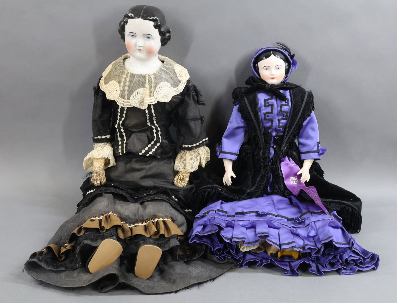 CHINA DOLLS.: Pair of dolls with molded black hair, painted blue eyes. Antique - Doll 1) 26" with center part hair, approx. 1870's style. Original cloth body, lower leather arms, individual fingers. Dressed in