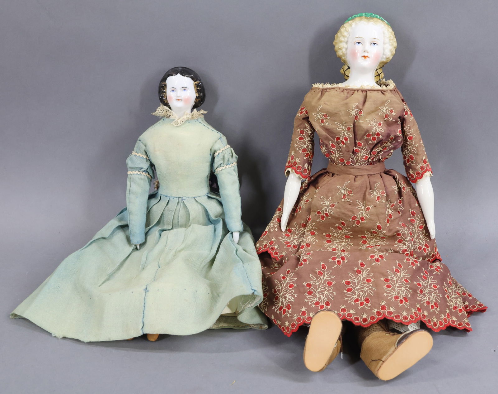 CHINA DOLLS.: Pair of antique dolls with snoods (or nets on back of heads). Both dolls have painted blue eyes, rosy cheeks, antique/vintage cloth bodies, china lower arms. Both are dressed in antique clothing.