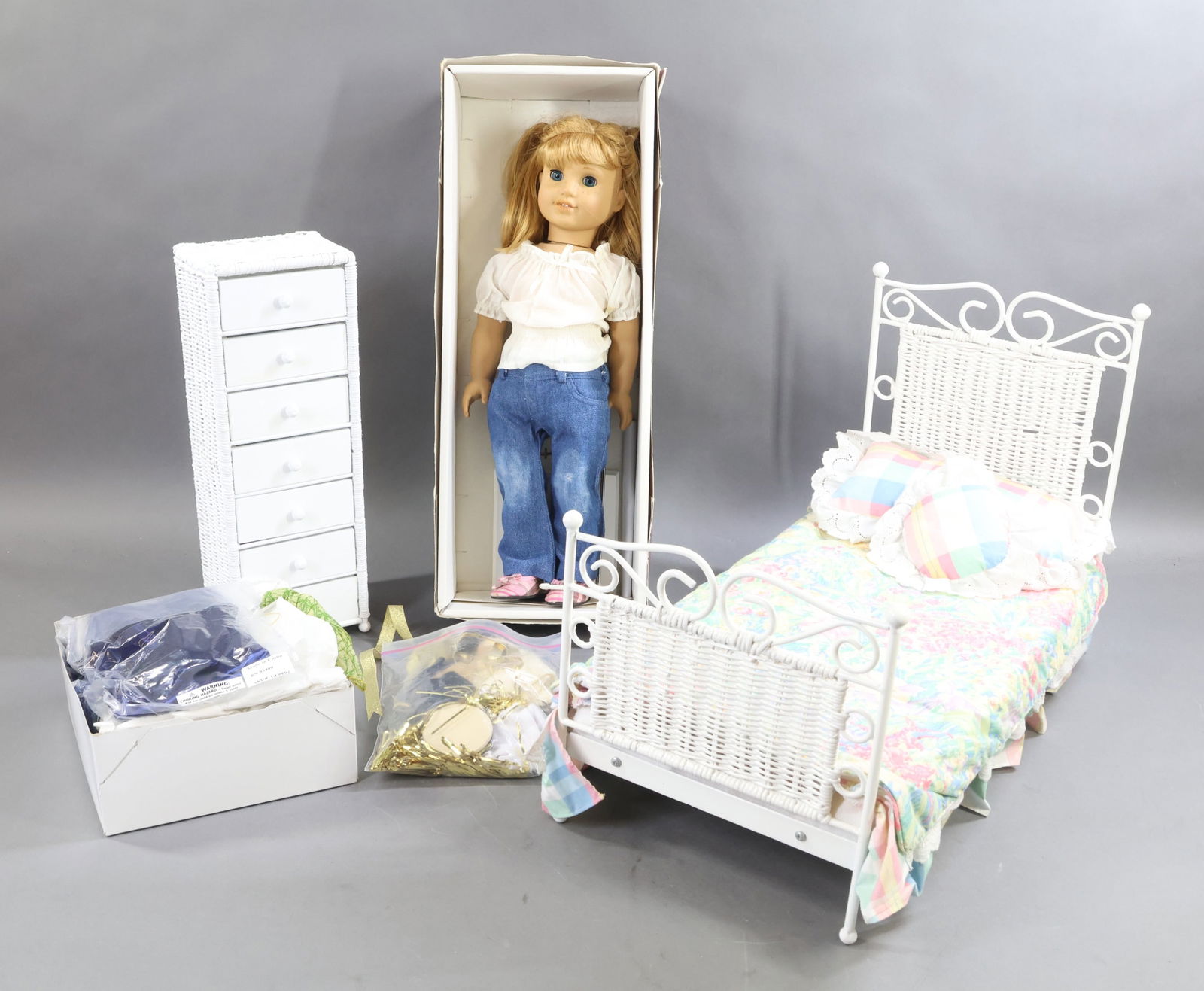 AMERICAN GIRL.: LOT. "Nellie" doll in OB. Unidentified white wicker bed with (2) pillows and linens. 4-Drawer wicker cabinet. (Bag of shoes, misc. accessories that came out of drawers.) Lot of MINT outfits from JUST