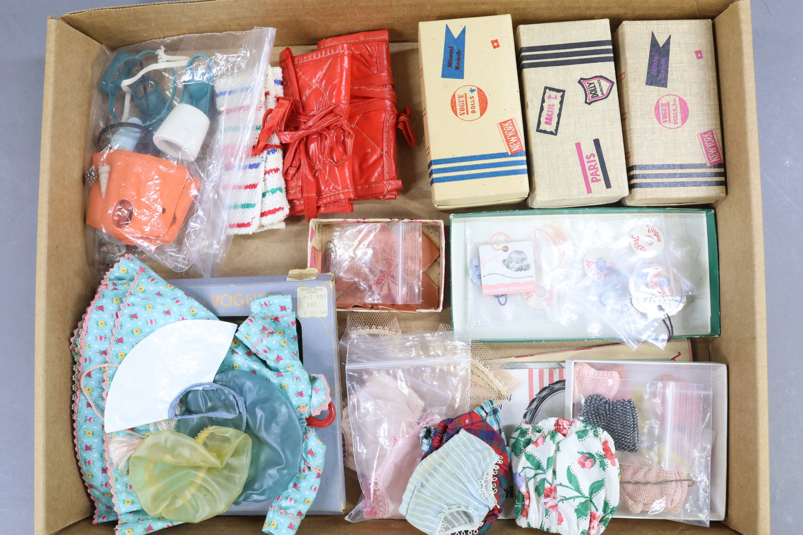 1940's-1960's DOLL ACCESSORIES.: LOT of items for 1950's-60's 8" VOGUE "Ginny" dolls. (3) Cardboard suitcases with various contents. (2) Ginny vinyl beach rollups. Towel beach rollup. Swimming gear inc. wooden logo bucket. (3) Tagged