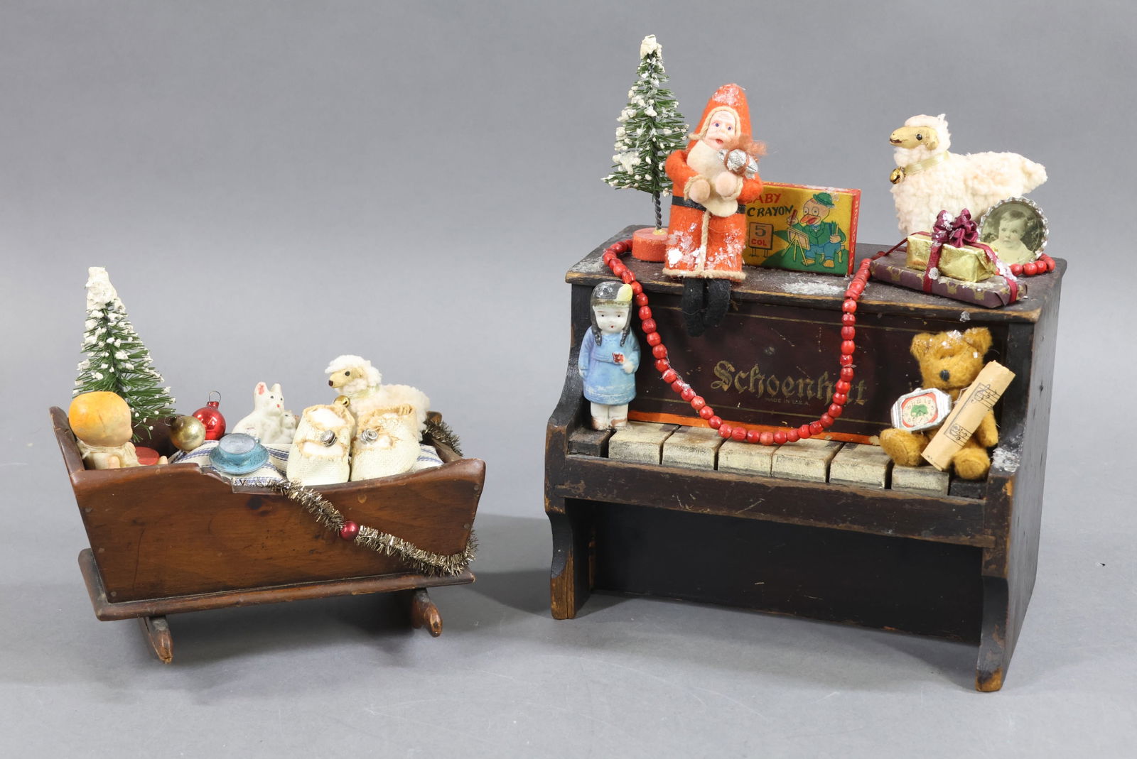 HOLIDAY/NOVELTIES.: HOLIDAY. CHRISTMAS. Pair of antique decorated items. SCHOENHUT wooden piano, 7 1/2" W x 6" T, decorated with Santa, bottle brush tree and other toys. Wooden cradle, 6 1/2" L x 3 1/2" T decorated with
