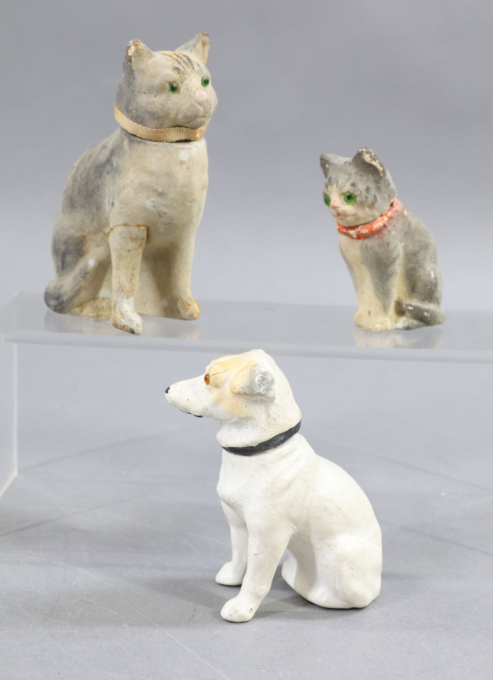 HOLIDAY/NOVELTIES.: NOVELTY. Lot of (3) antique German papier mache Candy Containers. 3 1/4" Sitting white Dog with amber glass eyes. 2 3/4" Sitting grey Cat with green glass eyes. (Age loss around collar.) 4" Sitting