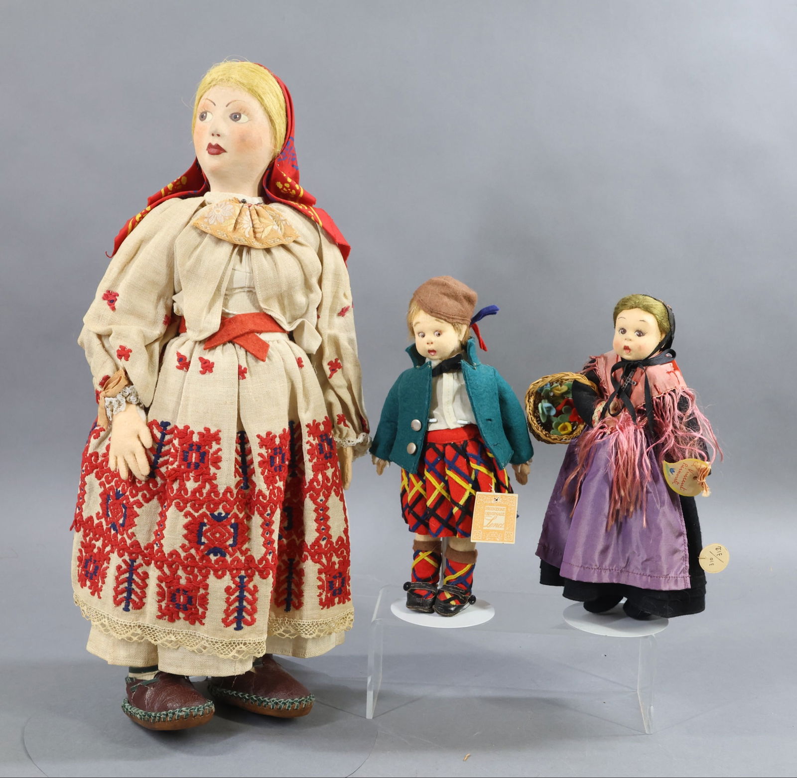 CLOTH DOLLS.: LOT of (3) dolls. Pair of all original 1930's 9" LENCI Mascottes. Scottish Boy with paper tag. Girl doll marked S. Vincent Piernoute. LENCI medallion 310/312. She is carrying a basket of felt