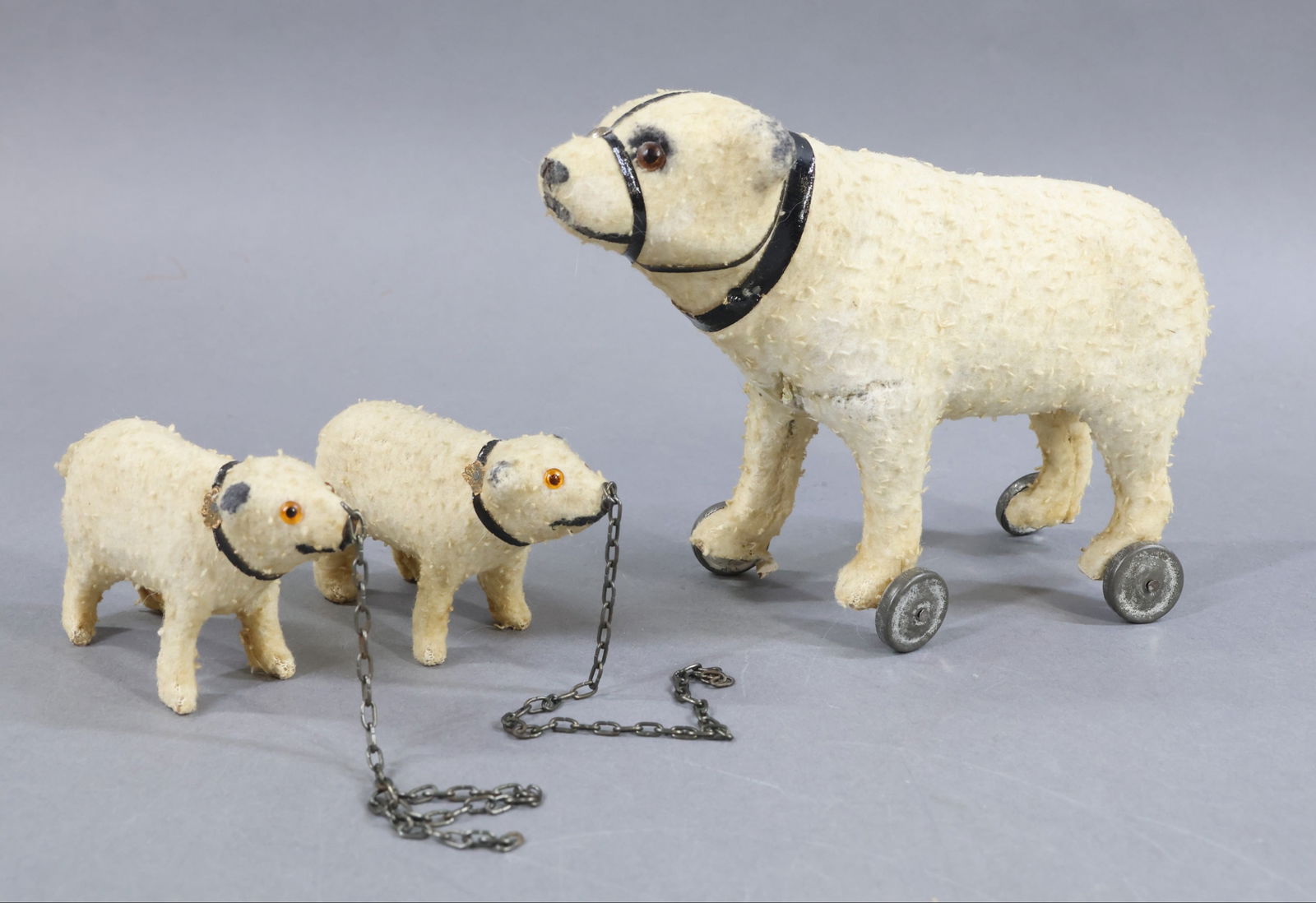 VINTAGE ANIMALS.: LOT of (3) German Polar Bears. All of them are covered with fleecy cotton fabric and they have amber glass eyes. 5 1/2" x 7" Bear is mounted on metal wheels as a pull toy. The "twins" are 2 1/4" x 3"