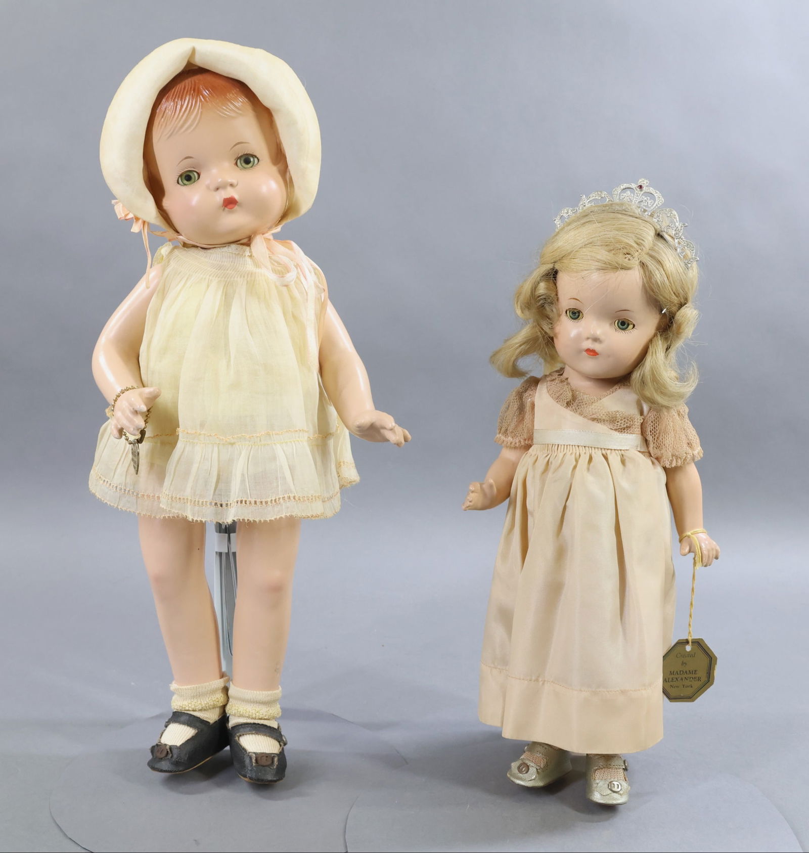COMPOSITION DOLLS.: Pair of dolls. Both dolls have blue sleep eyes, all original clothing and shoes. Doll 1) 13" MADAME ALEXANDER "Princess Elizabeth" doll. Blonde HH wig. Dressed in all original tagged clothing, silver