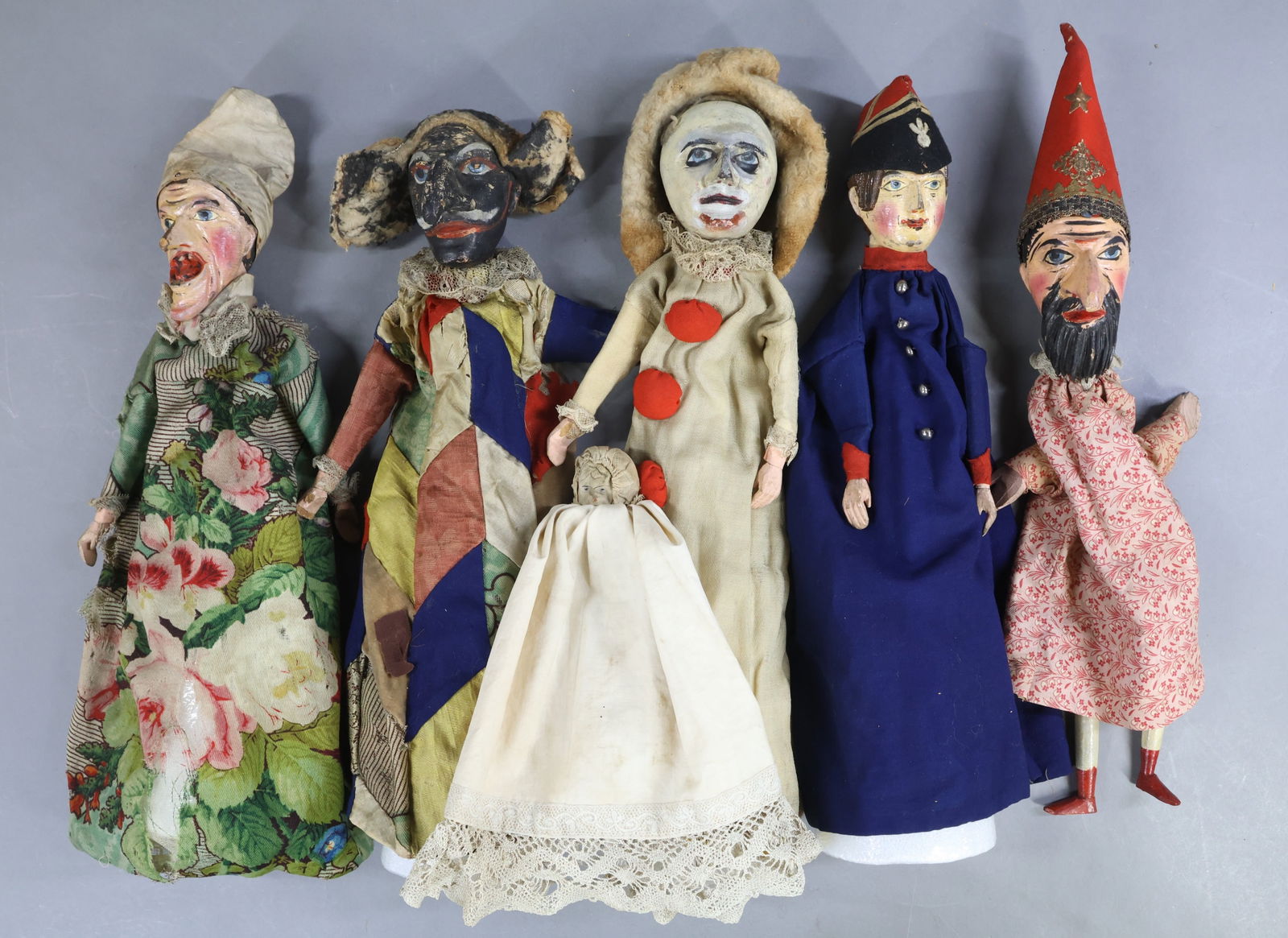 NOVELTY TOYS.: LOT of (5) antique "Punch & Judy" type puppets with carved wooden heads. They all have wooden hands and only (1) has wooden lower legs. (4) Are mounted on styrofoam cones. They appear to be all