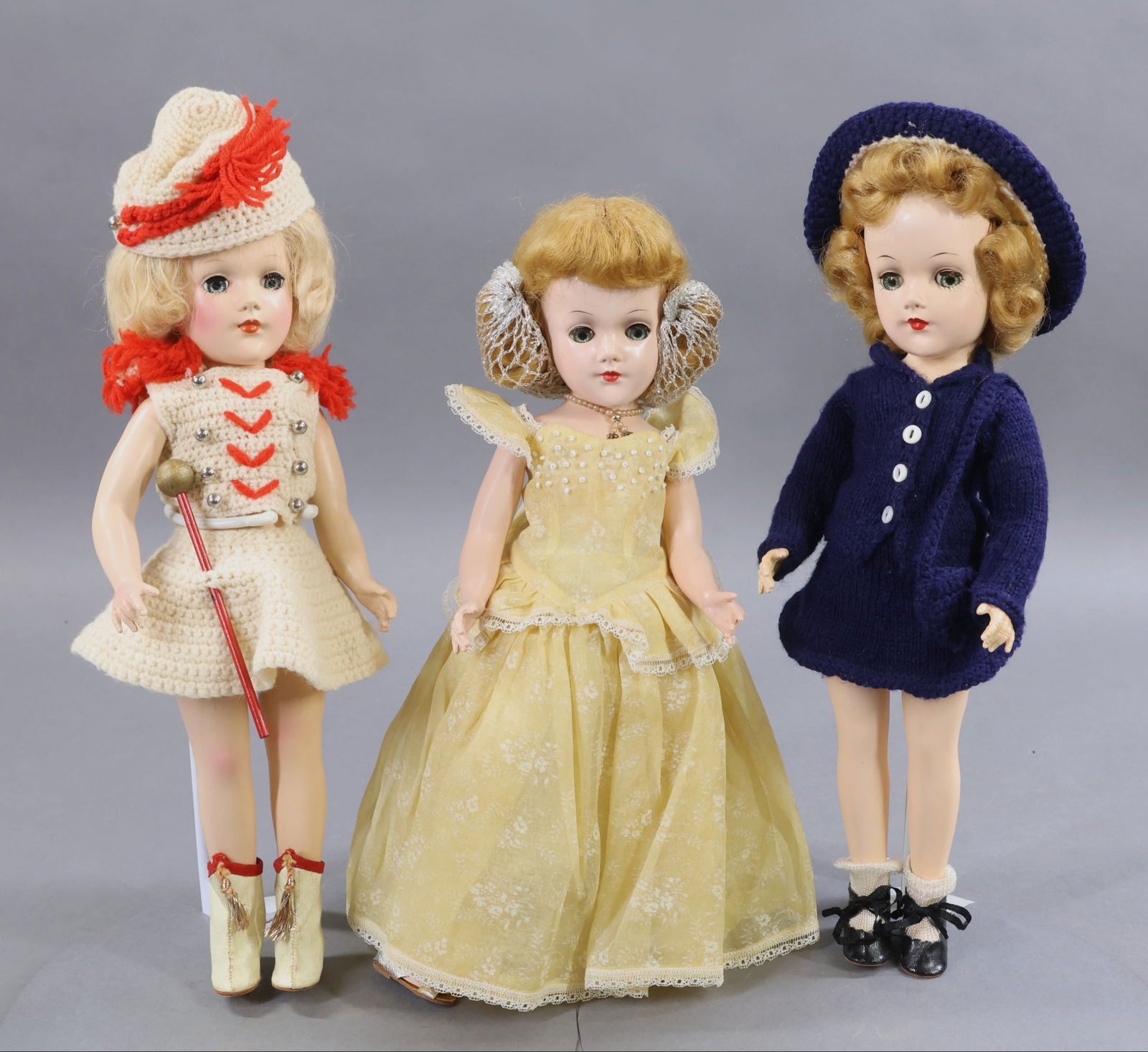 1950's-1960's DOLLS.: LOT of (3) 14" hard plastic MARY HOYER dolls. (2) Of them are dressed in outfits knit from the Mary Hoyer patterns. They all have blue sleep eyes. Doll 1) "The Majorette" with her baton. Blonde mohair
