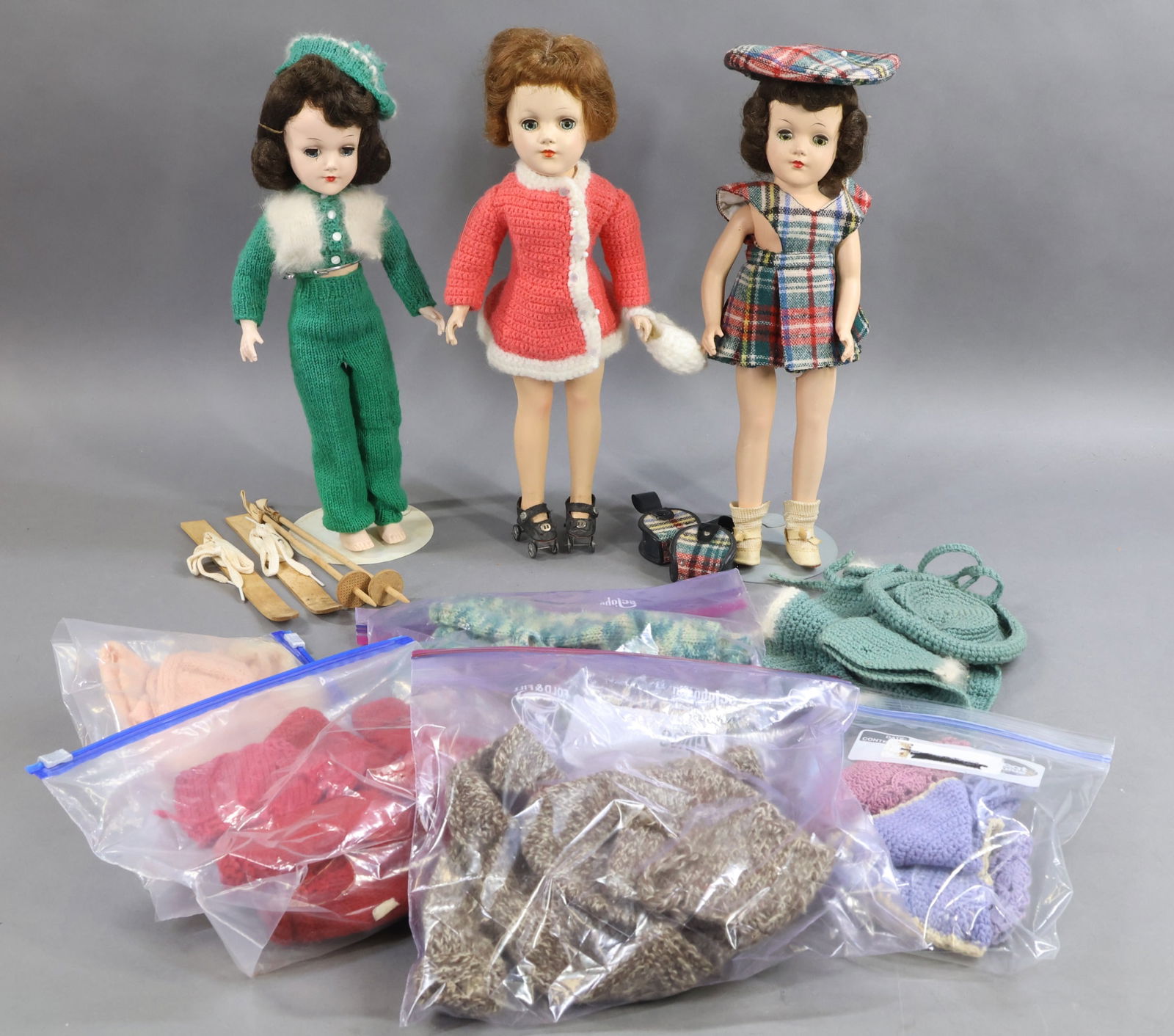 1950's-1960's DOLLS.: LOT of (3) 14" hard plastic MARY HOYER dolls and additional knit clothing. All of the dolls have blue sleep eyes. (2) Dolls are dressed in outfits knit from Mary Hoyer patterns. Doll 1) with dark brow