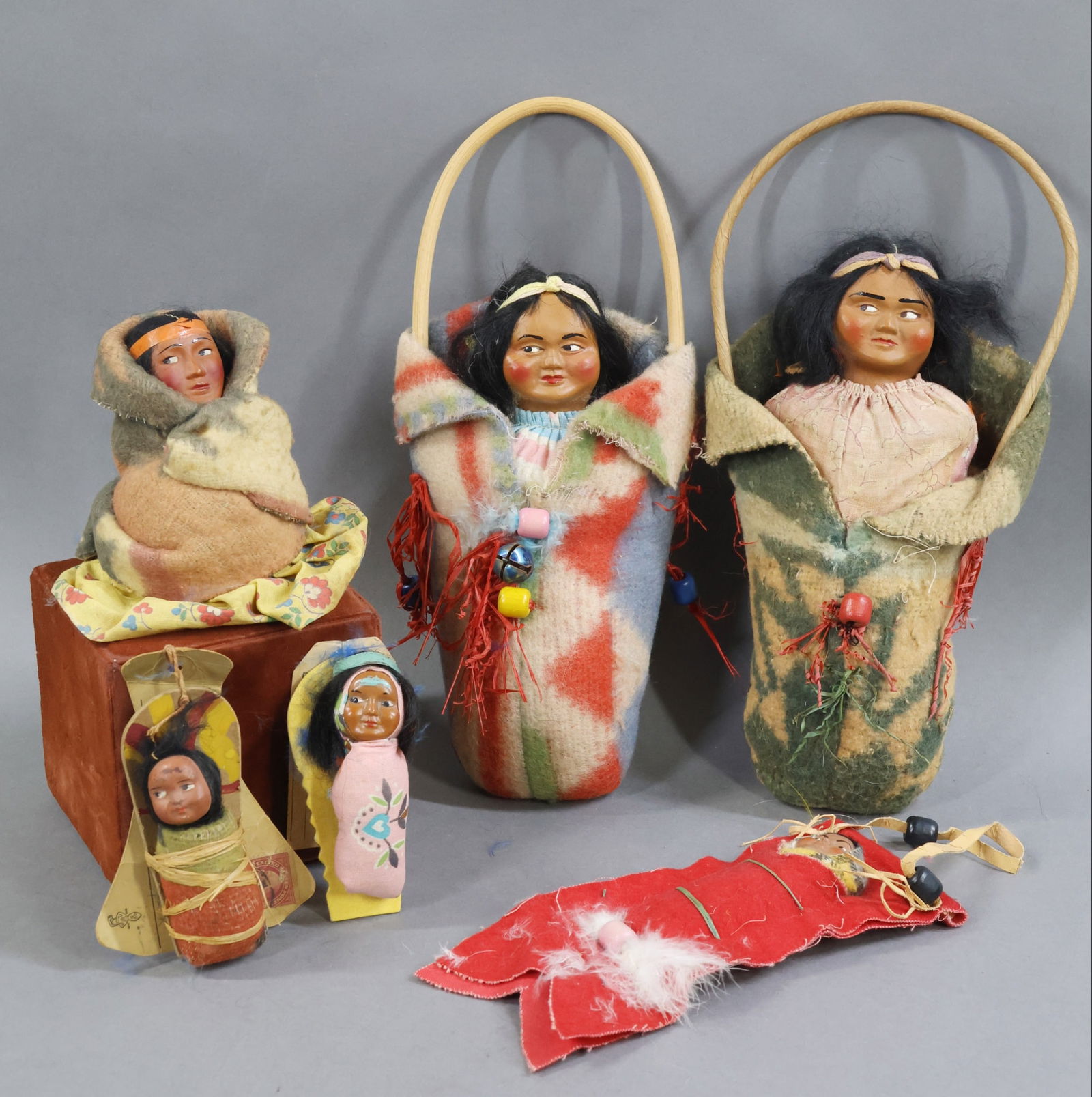 NATIVE AMERICAN DOLLS.: LOT of (5) all original SKOOKUM Children dolls. Pair of Indian Papoose "Mailers". 4" 1920's Postcard mailer with 2 cent stamp on it. 3" Mailer which required a 3 cent stamp. 7" 1940's Papoose in felt