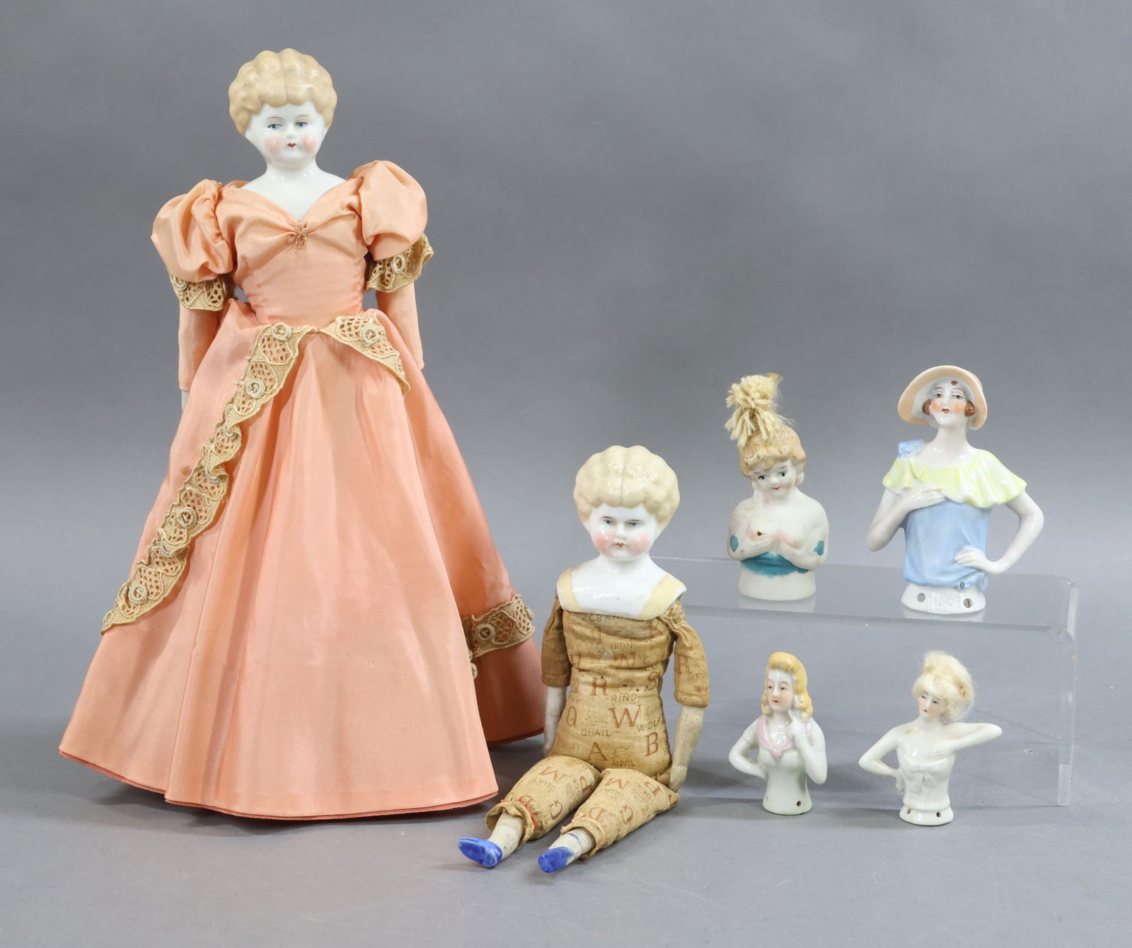 CHINA DOLLS.: LOT . (2) Blonde Lowbrow dolls with blue eyes. Doll 1) 9 1/2" with printed cloth body, parian lower limbs. NO clothing. (Age loss on body.) Doll 2) 12" marked GERMANY with cloth body, parian/china