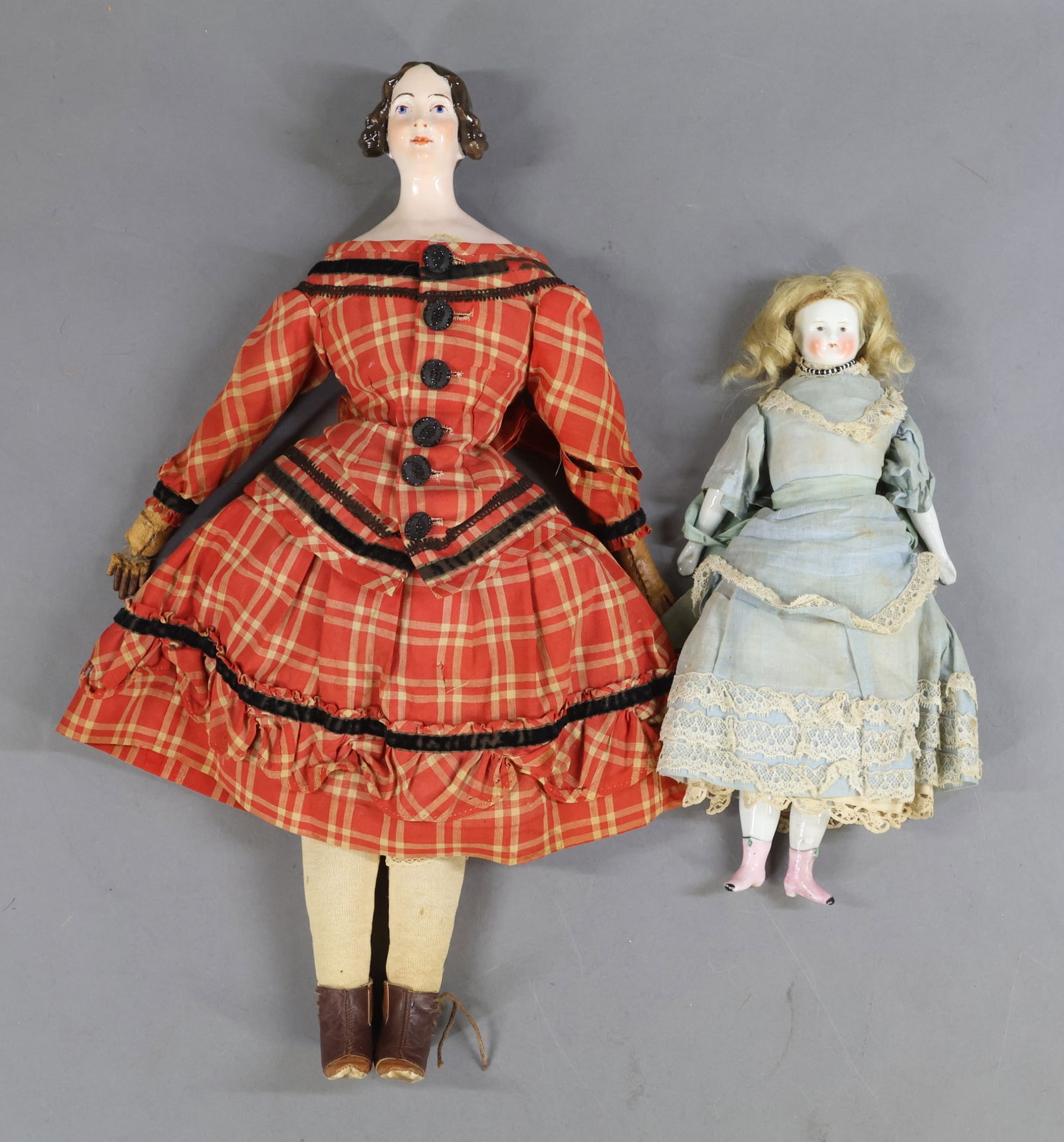 CHINA DOLLS.: Pair of dolls. Both dolls have painted blue eyes and antique cloth bodies. They are wearing antique clothing. Doll 1) 10 1/2" Solid dome with blonde mohair wig. China lower arms and legs with painted