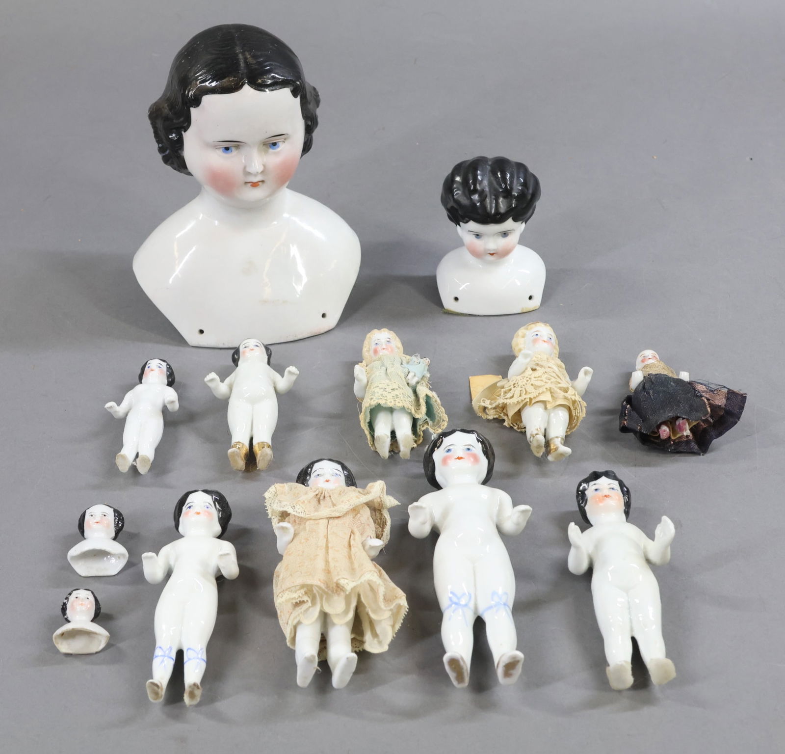 CHINA DOLLS.: LOT. (4) China shoulder heads with painted blue eyes, black center part hair. 3 1/2" "1" Lowbrow and 6 1/2" . (2) 1 1/4" To make dollhouse size dolls. (8) Frozen Charlotte style dolls. 4" Dressed Blon